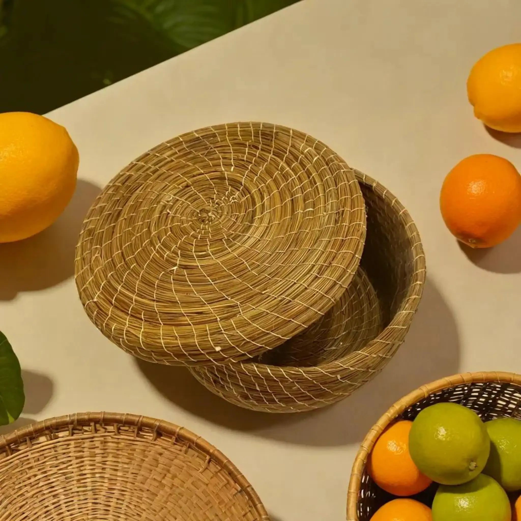 Boîte de rangement en halfa avec couvercle, posée dans une cuisine avec des fruits frais à côté.
