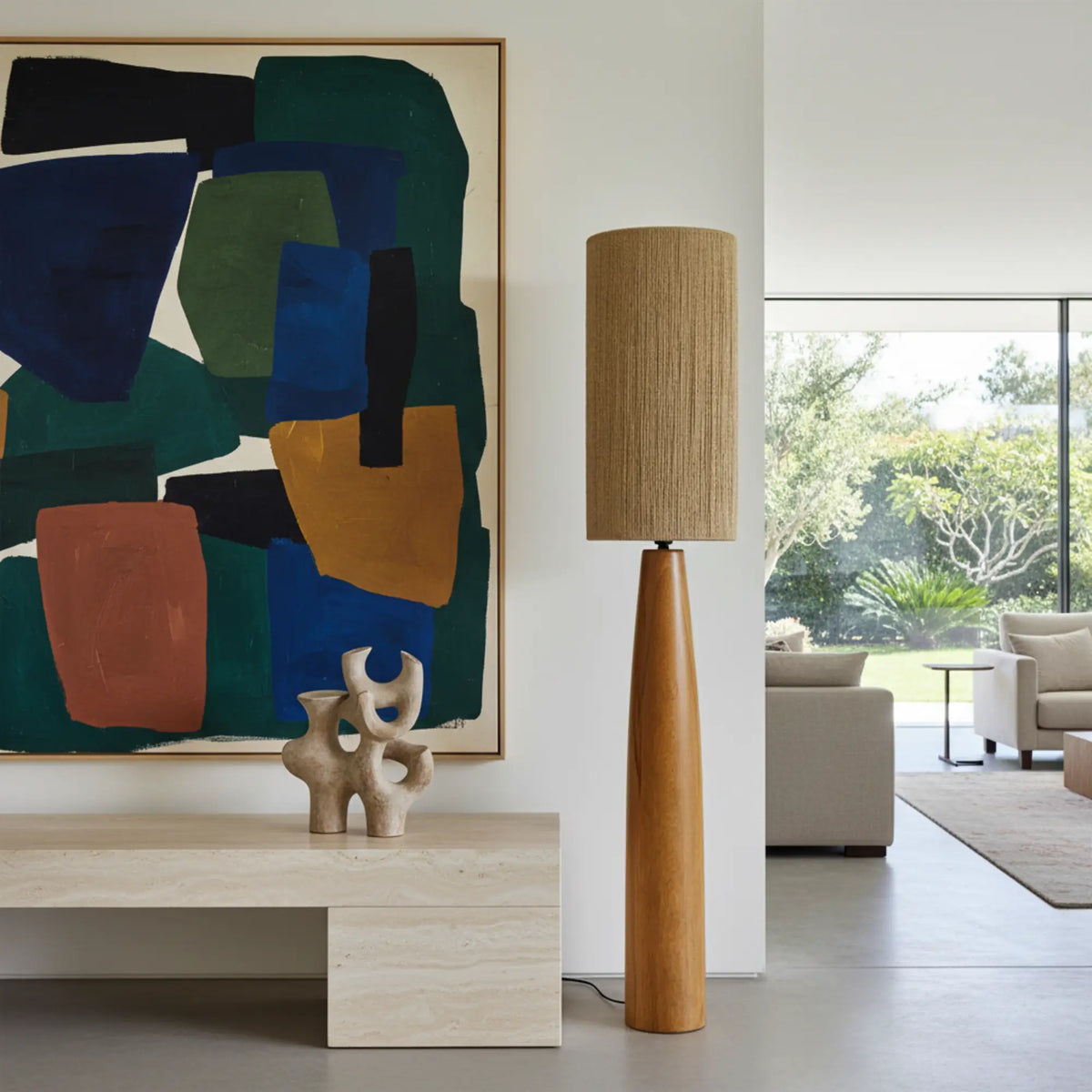 Lampadaire en bois et jute à côté d'un banc en travertin et d'un grand tableau abstrait vert