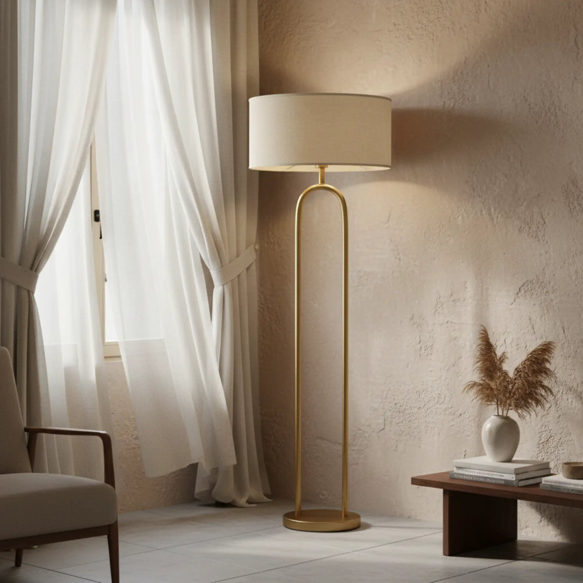 Lampadaire arceau doré près d'une fenêtre aux voilages blancs, devant un mur à la chaux et une table basse en bois