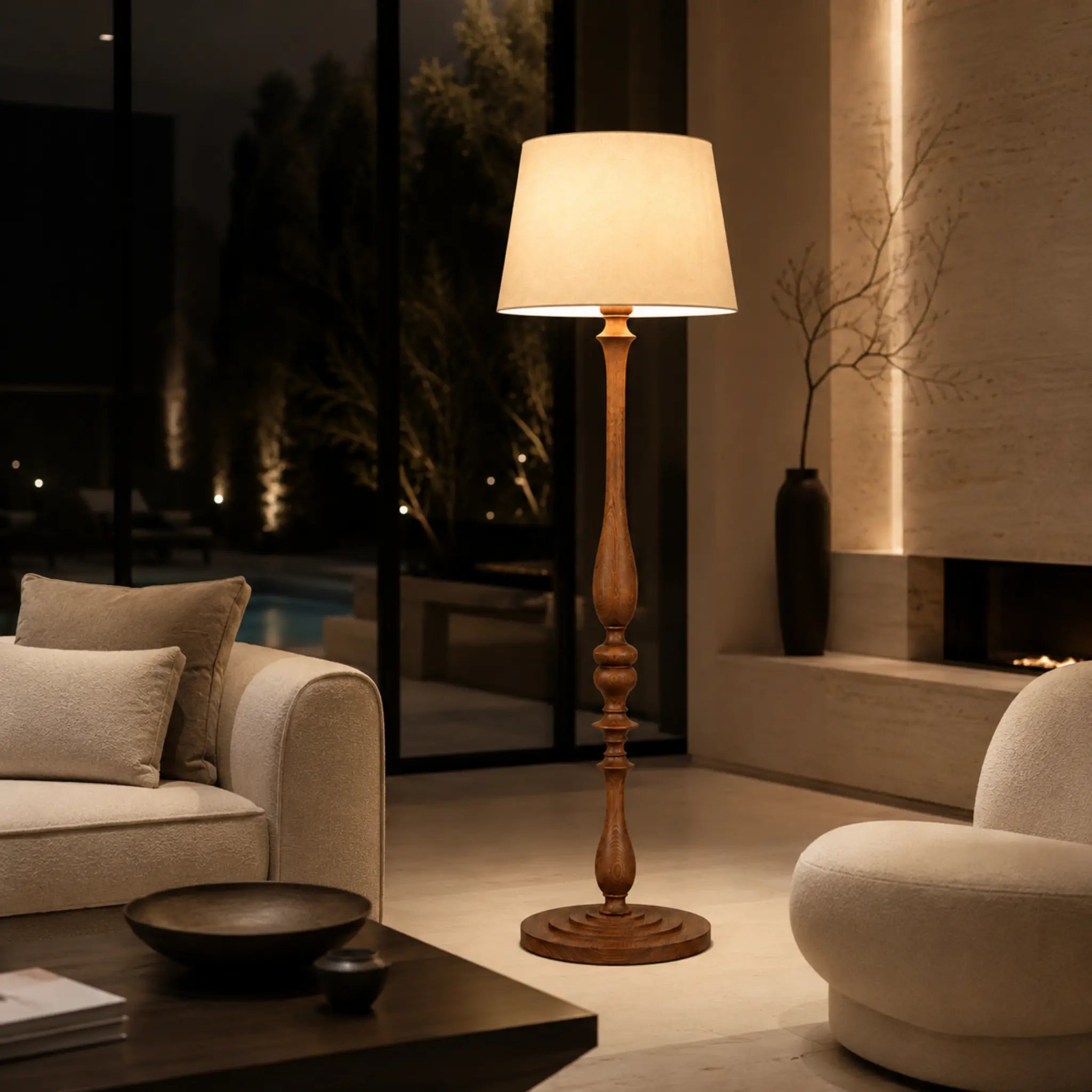Lampadaire en bois tourné allumé le soir, lumière tamisée et ambiance cosy dans un salon moderne en Tunisie