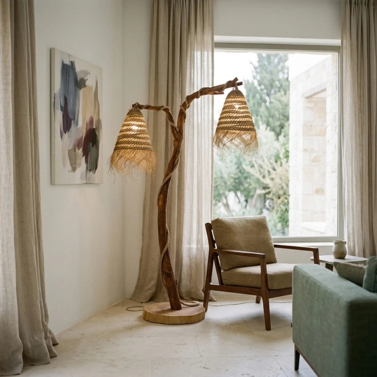 Lampadaire de lecture en bois flotté à deux abat-jour près d'un fauteuil en bois devant la fenêtre, à côté d'un canapé vert