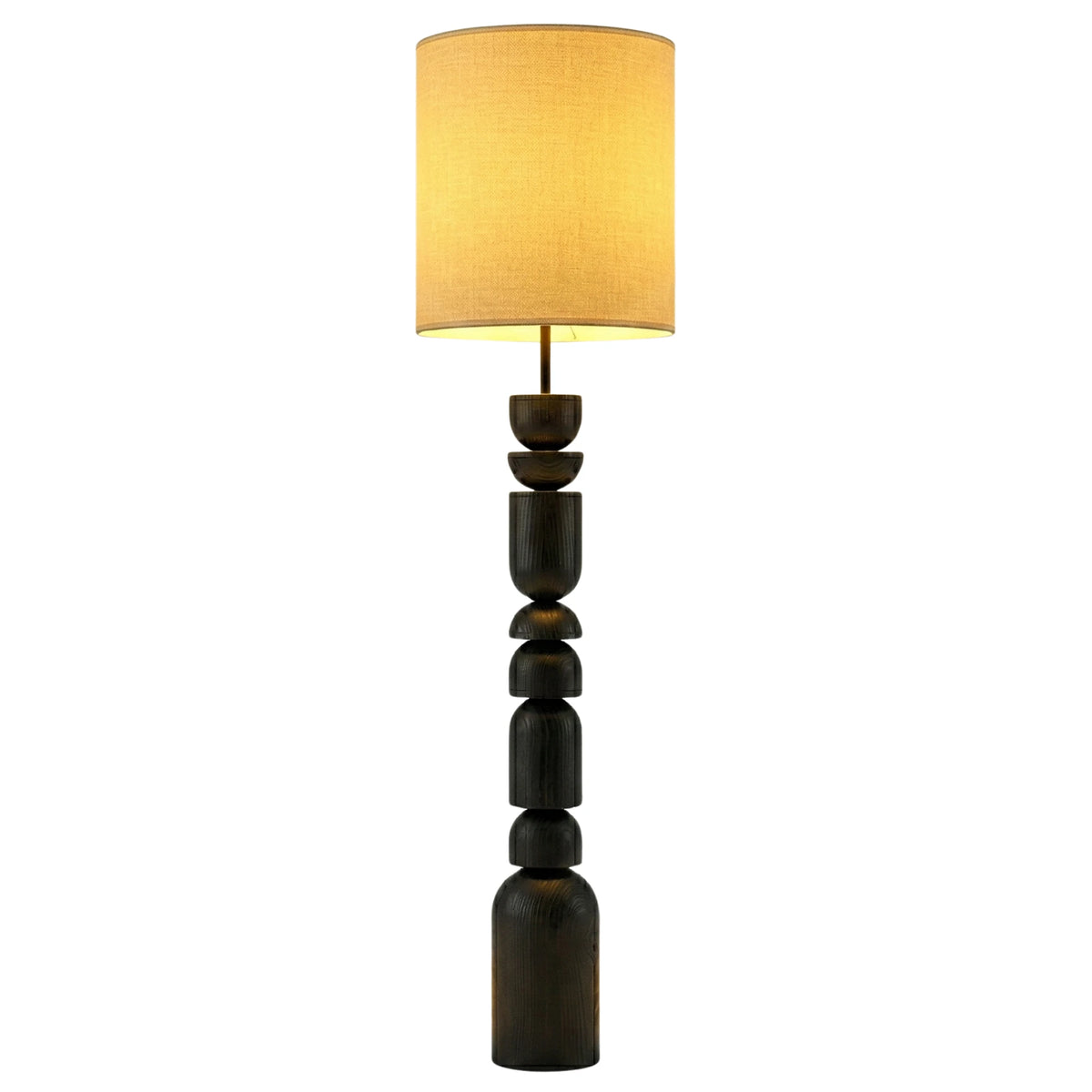 Lampadaire colonne au pied en bois foncé tourné à la main et abat-jour cylindrique en lin allumé, sur fond blanc