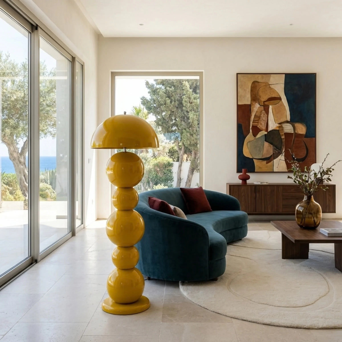 Lampadaire design jaune près d'un canapé bleu pétrole et d'une console en bois, vue sur les oliviers