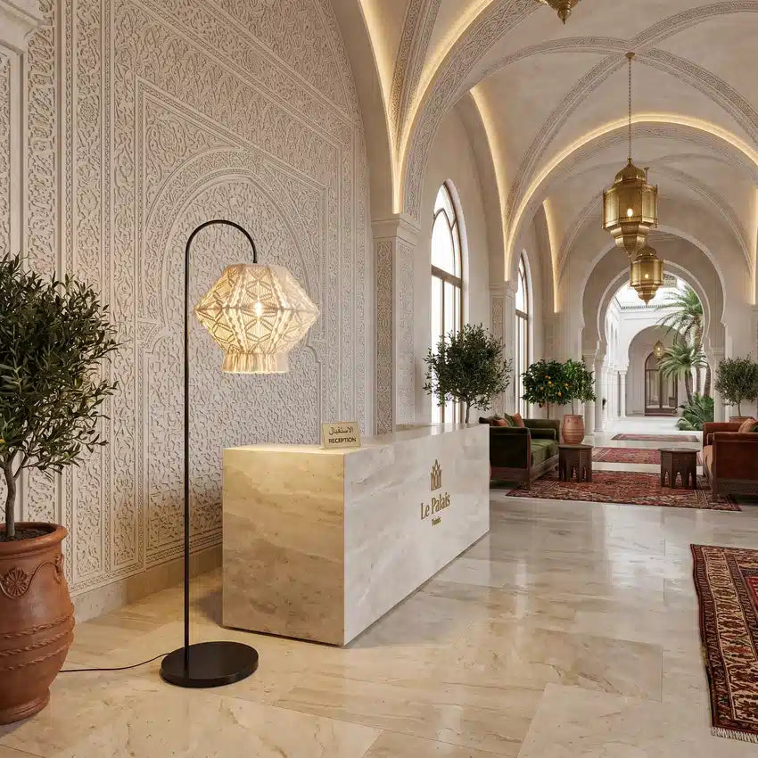 Lampadaire arc macramé à côté d'un comptoir de réception en pierre, dans un hall d'hôtel voûté