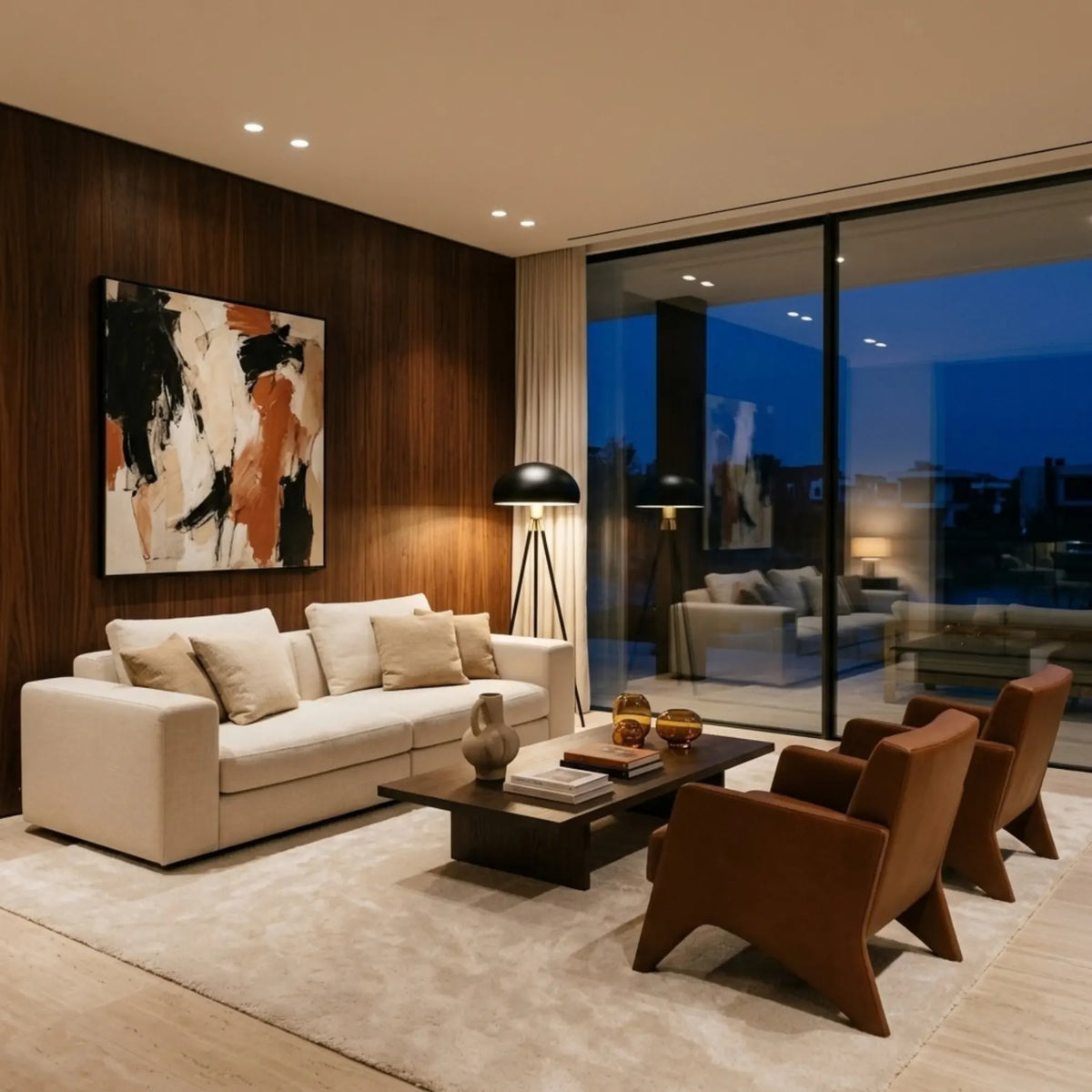 Lampadaire noir et doré dans un grand salon aux murs en bois sombre, avec canapé crème, fauteuils en cuir et baie vitrée sur la ville