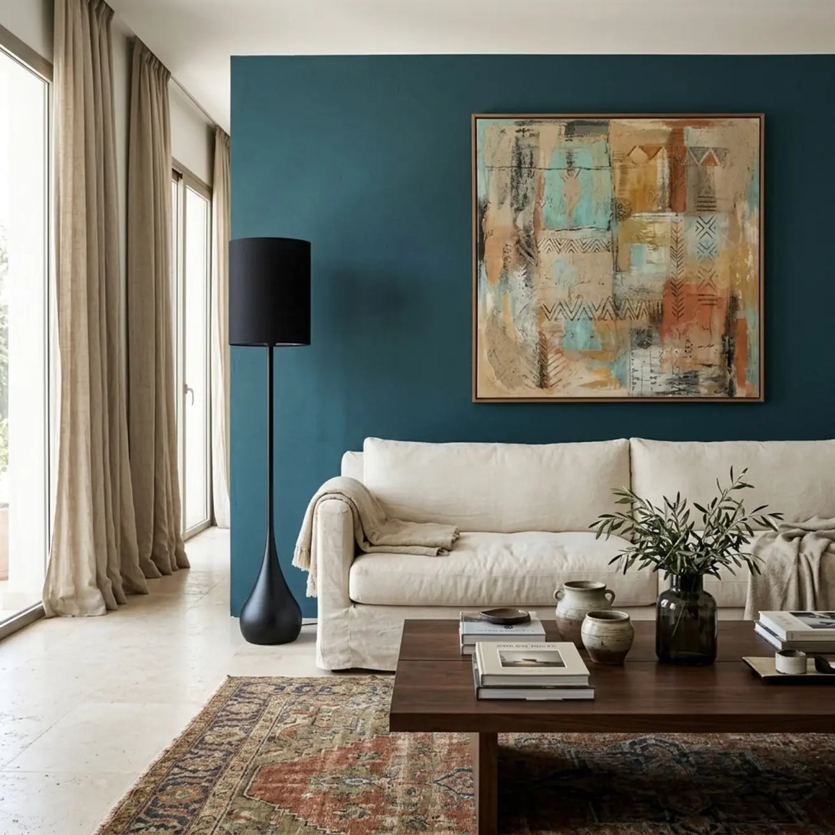 Lampadaire noir devant un mur bleu pétrole, à côté d'un canapé crème et d'un tapis à motifs