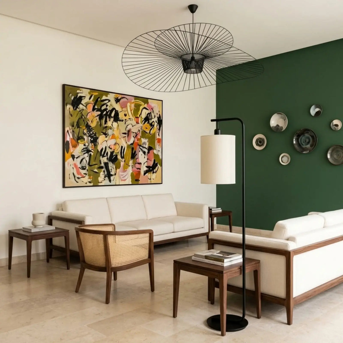Lampadaire noir entre deux canapés blancs, devant un mur vert décoré d'assiettes