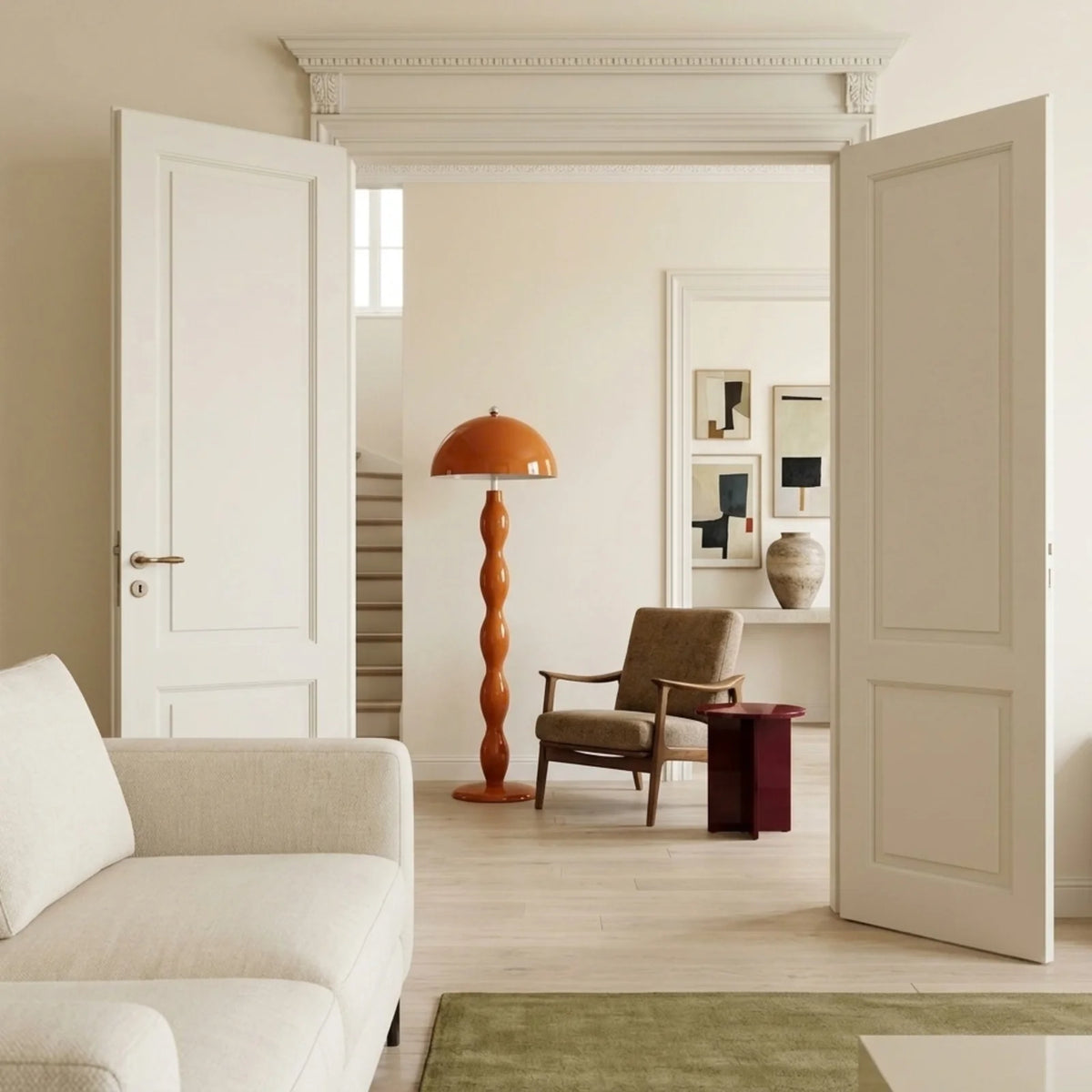 Lampadaire orange design près d'un fauteuil vintage dans un salon classique aux murs crème