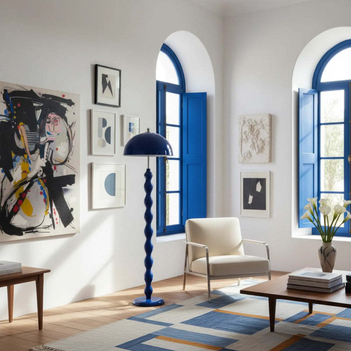 Lampadaire bleu dans un salon moderne blanc aux fenêtres cintrées bleues, près d'un fauteuil crème