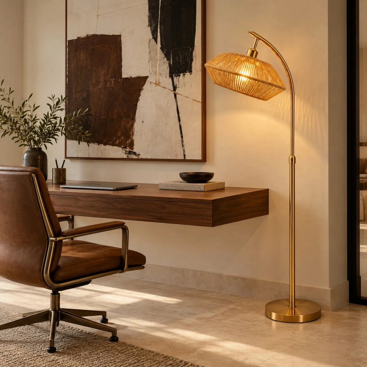 Lampadaire doré à abat-jour jute éclairant un bureau suspendu en bois avec fauteuil en cuir
