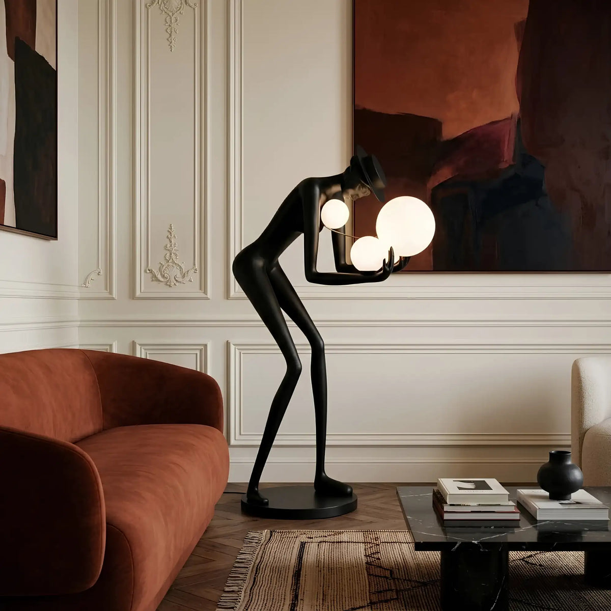 Lampadaire sculpture noire dans un salon classique chic à moulures près d'un canapé rouille