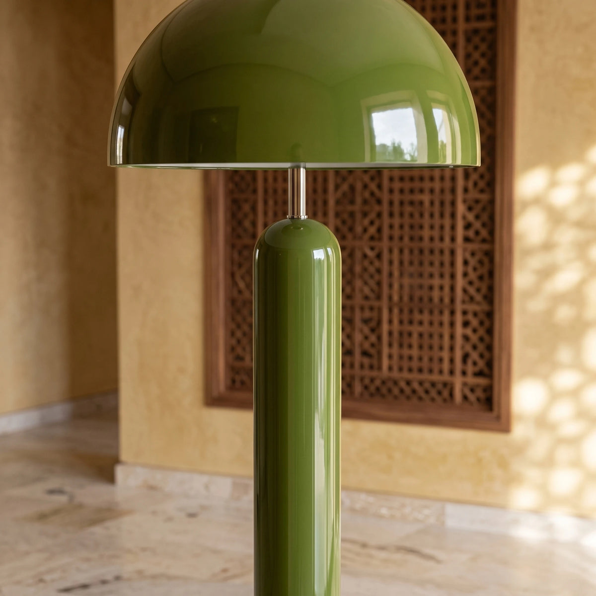 Dôme et pied cylindrique du lampadaire vert devant un moucharabieh en bois