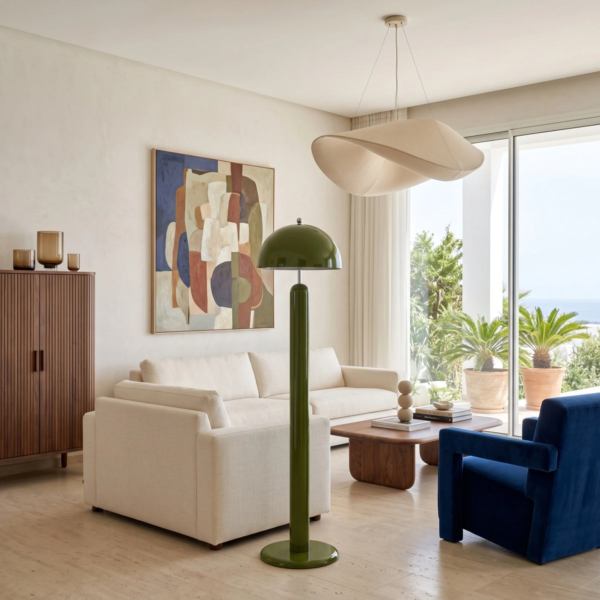Lampadaire de salon vert à côté d'un fauteuil bleu roi et d'un canapé blanc, vue sur le jardin