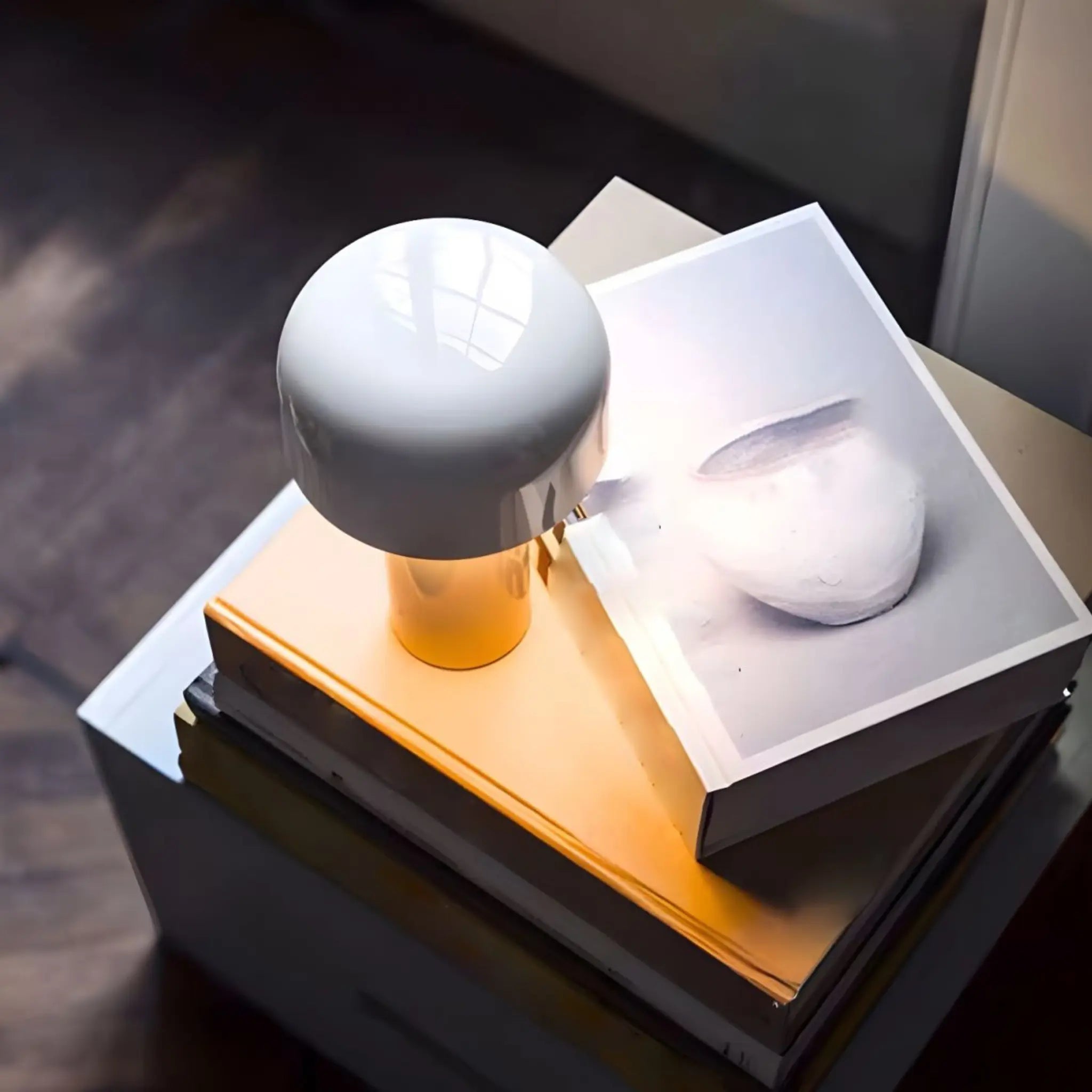 Lampe de lecture LED blanche au design champignon, posée sur une pile de livres, pour une ambiance de chevet en Tunisie.