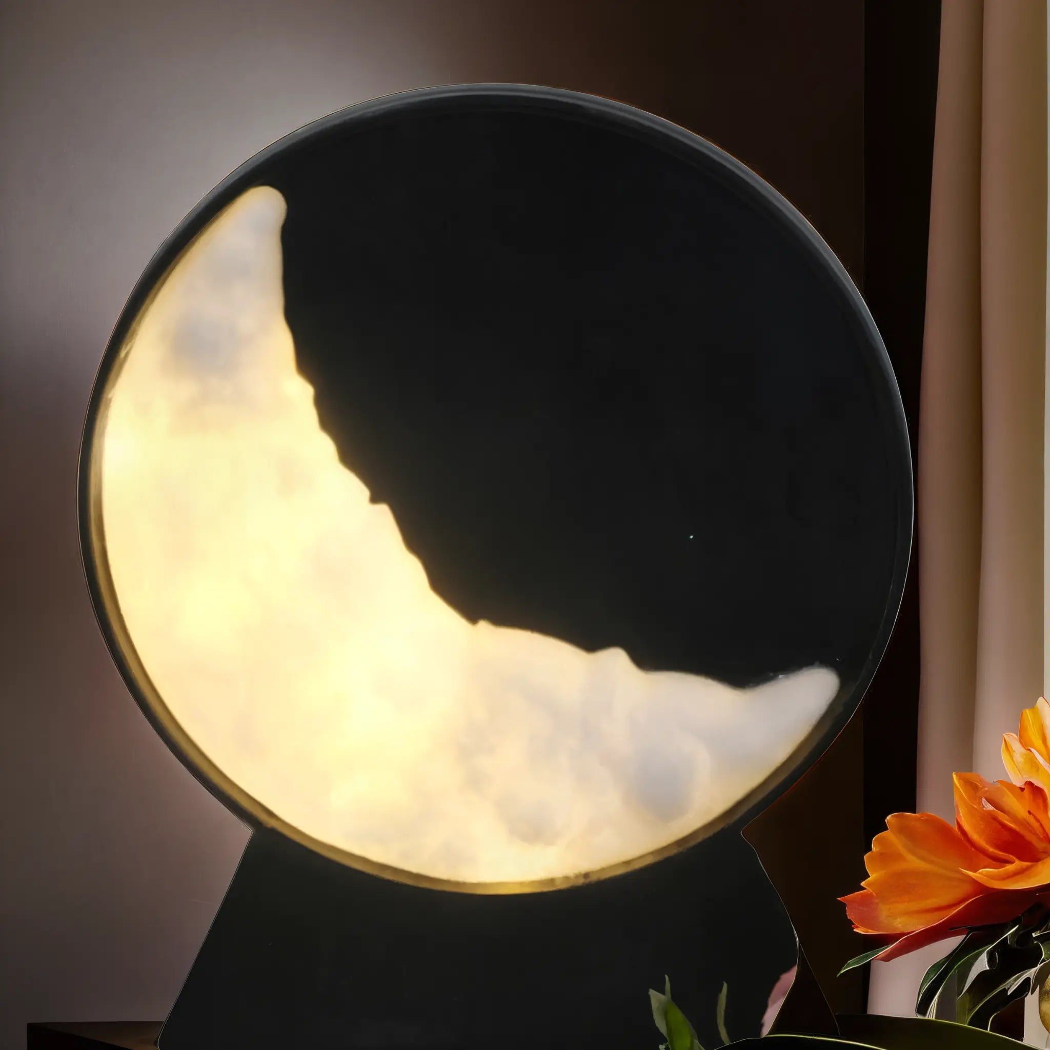 Lampe en forme de croissant de lune avec une lumière dorée chaleureuse, accompagnée de fleurs orange éclatantes pour un décor apaisant et raffiné.