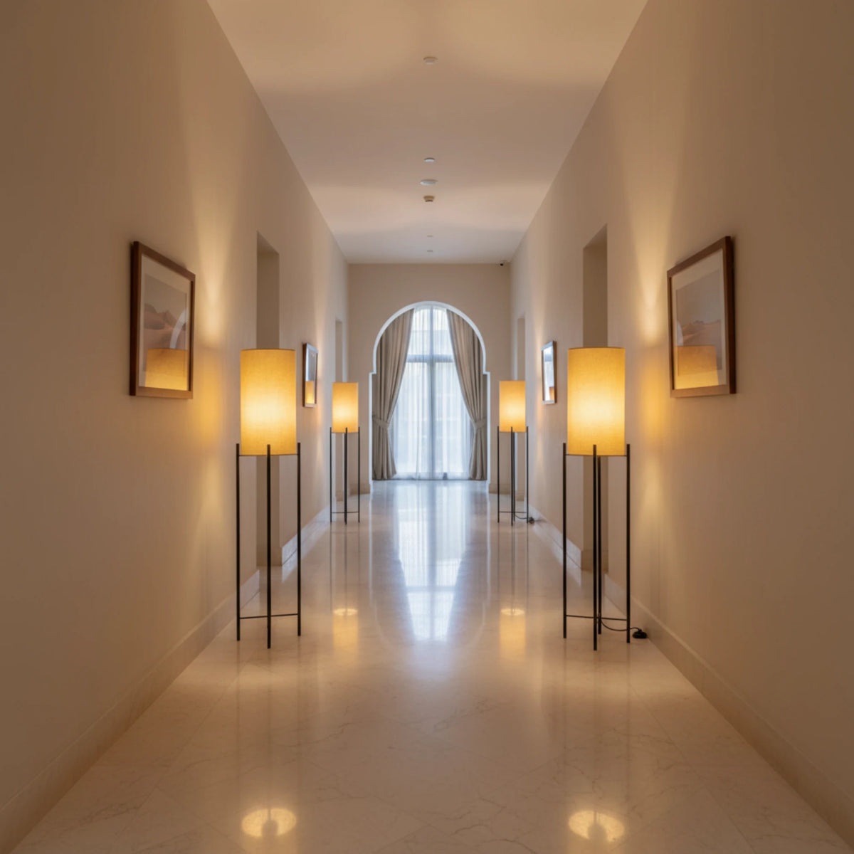 Lampes sur pied en lin beige alignées le long d'un couloir clair, éclairage chaud