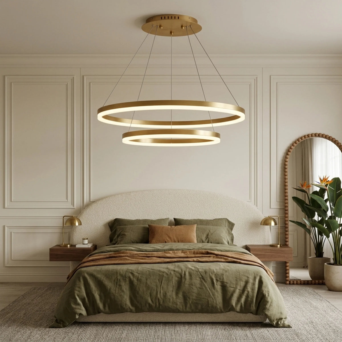Lustre à anneaux LED doré dans une chambre aux tons verts et tête de lit bouclée