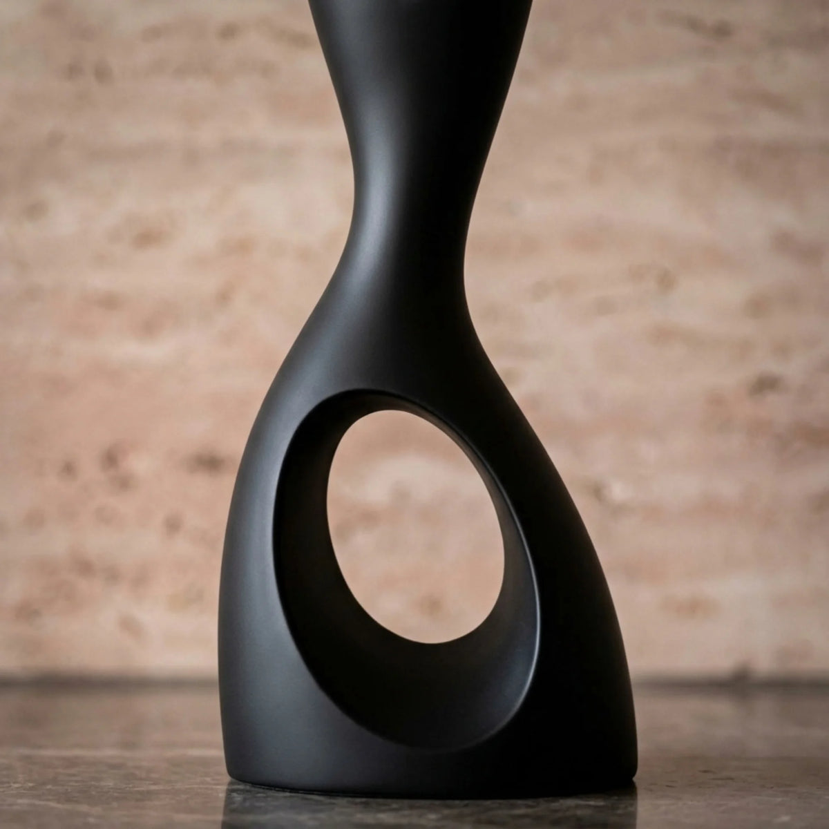 Détail du pied ajouré aux courbes sculptées du lampadaire noir mat