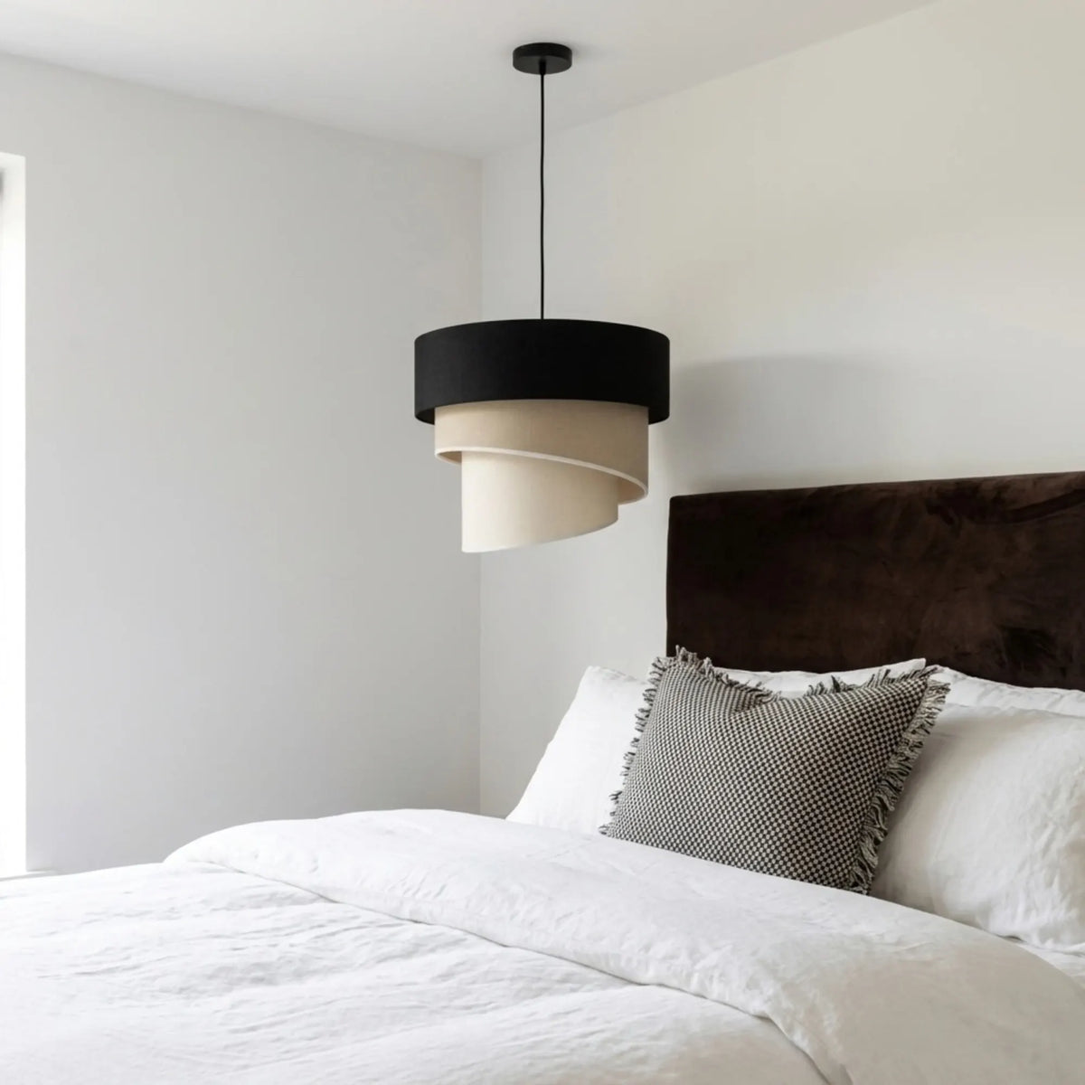 Suspension noir, beige et crème dans une chambre blanche à tête de lit en velours chocolat