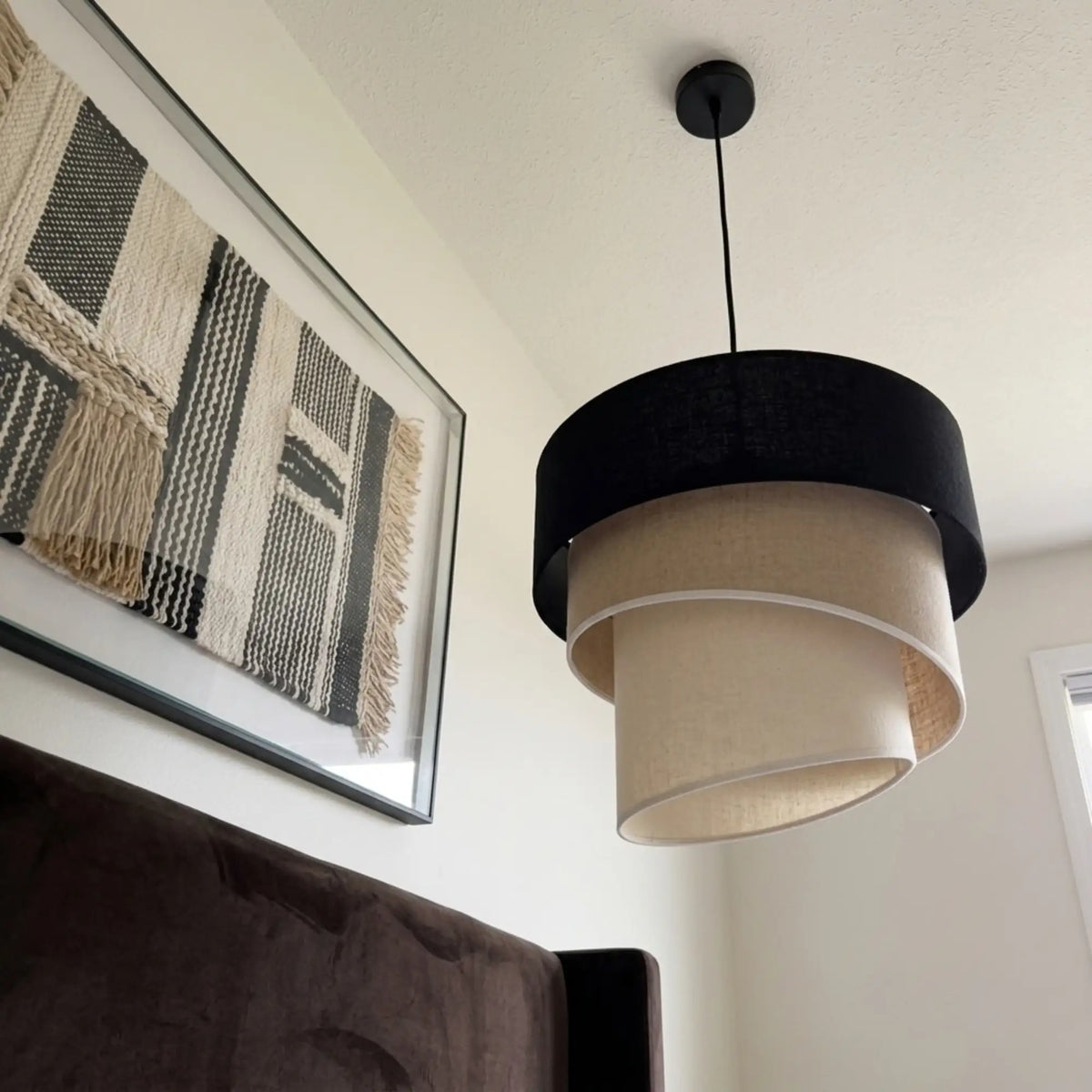 Suspension trois tons vue en contre-plongée, près d'un tableau tissé à franges