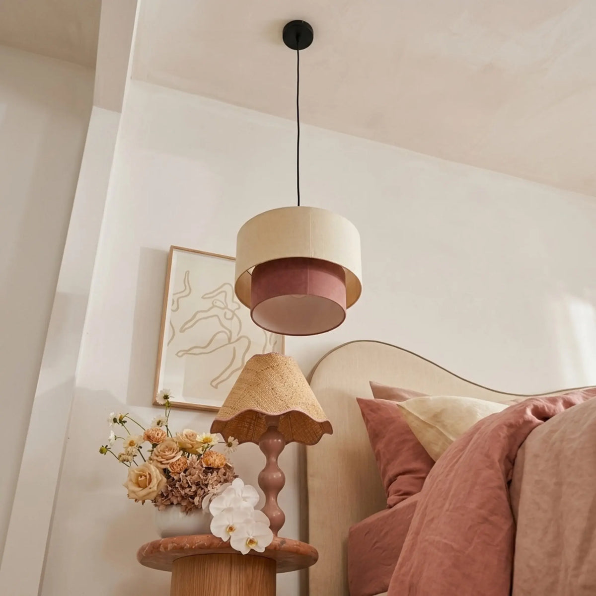 Suspension bicolore vue en contre-plongée, près d'une lampe de chevet à abat-jour festonné