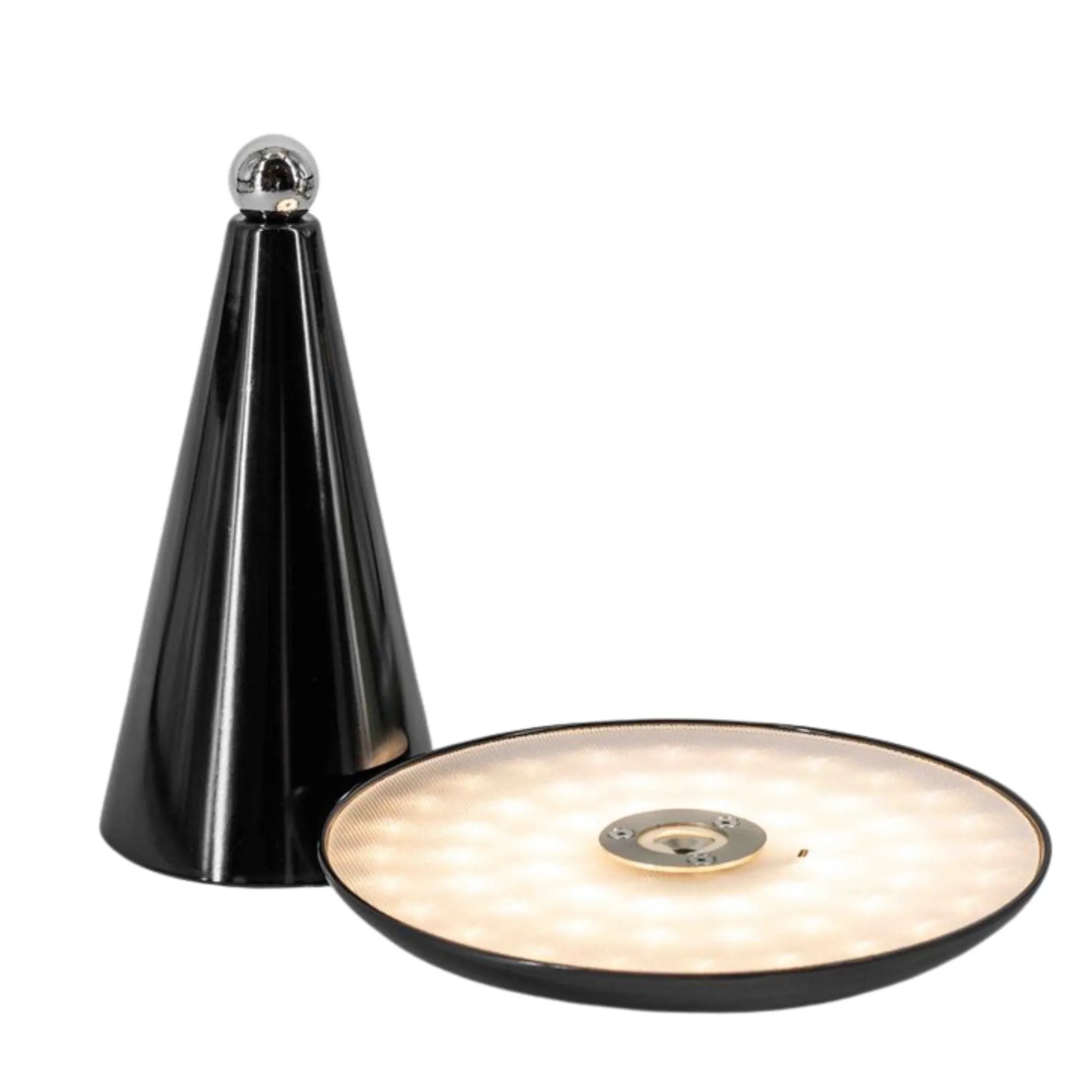 Une base de lampe conique noire et brillante se trouve à côté de son diffuseur de lumière LED rond et détaché, qui est allumé et lumineux.