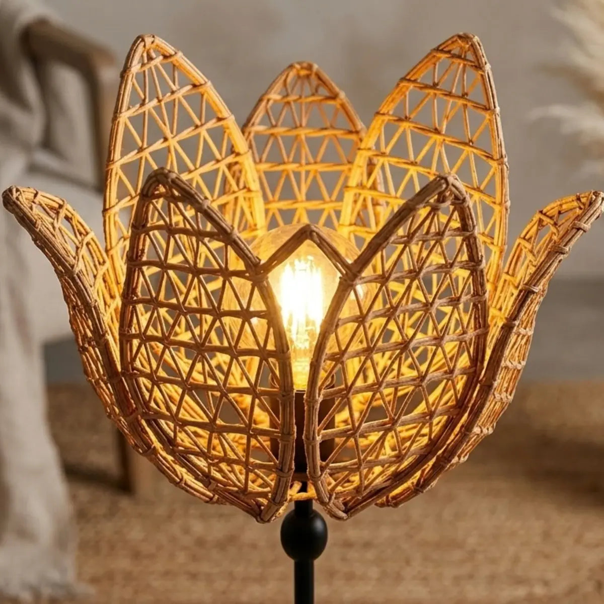 Gros plan de l'abat-jour fleur en fibre de palmier tressée, allumé avec une ampoule filament