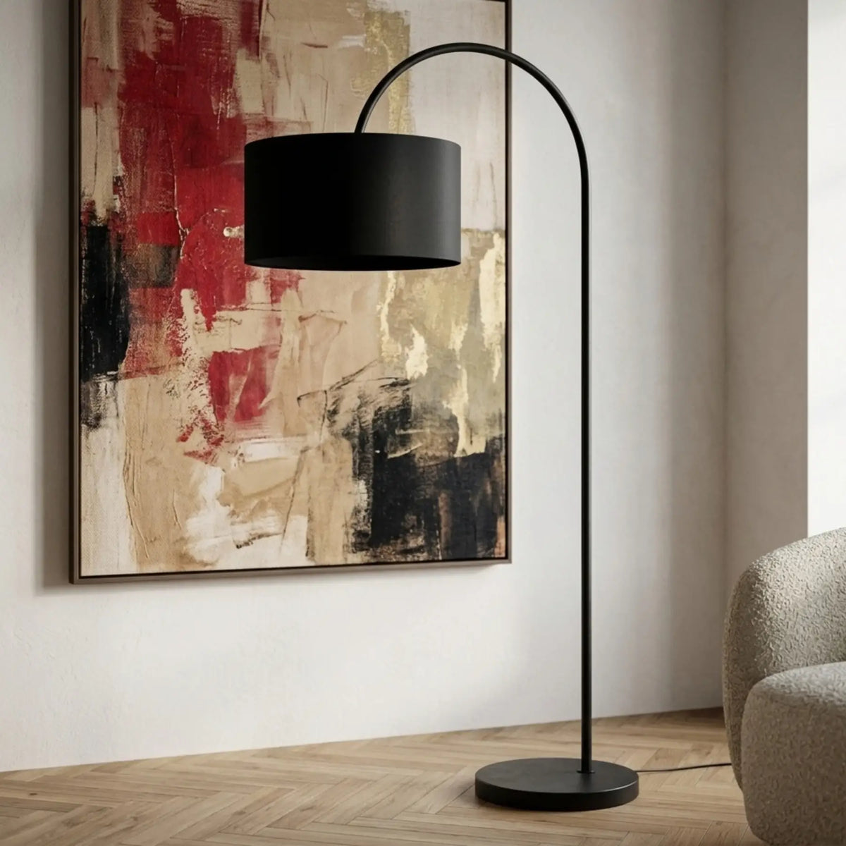 Lampadaire arc noir devant un grand tableau abstrait rouge et beige, à côté d'un fauteuil bouclette
