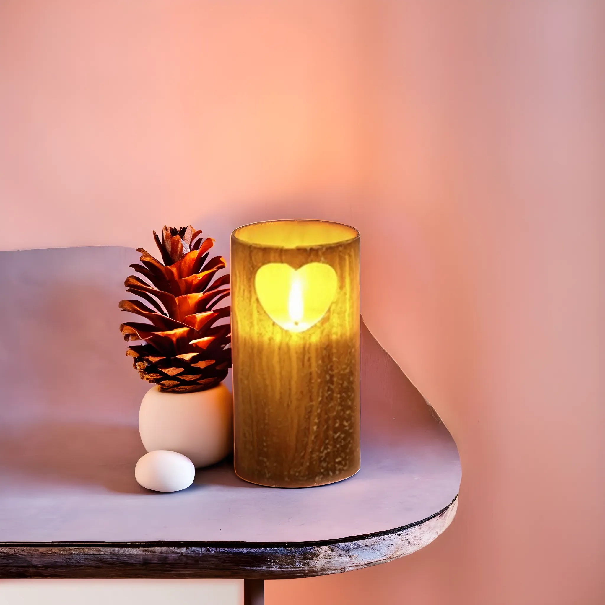 Bougie LED en bois avec découpe cœur, posée sur une table avec pomme de pin pour une ambiance romantique et chaleureuse.