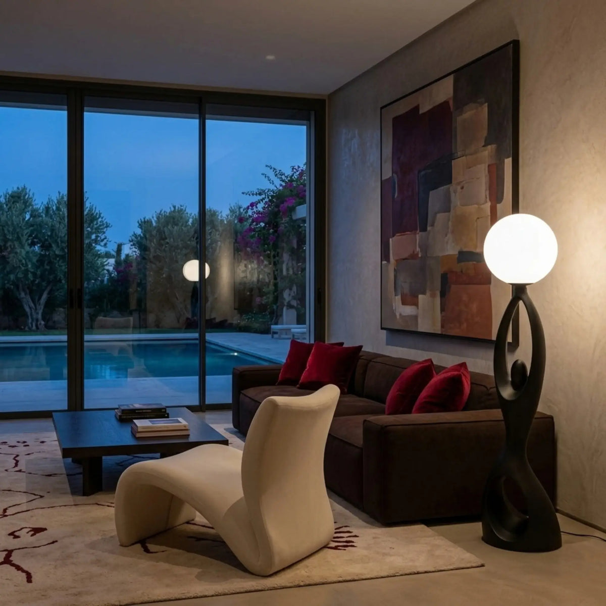 Lampadaire allumé le soir dans un salon avec canapé brun et vue sur la piscine