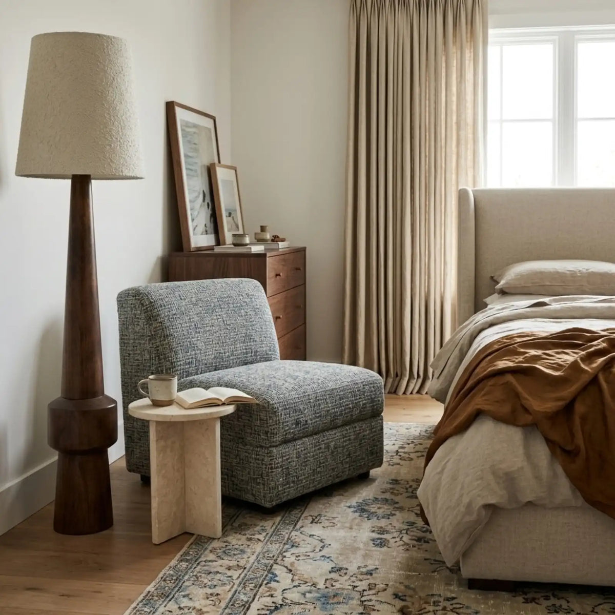 Lampadaire Atlas dans une chambre, près d'un fauteuil en tissu chiné vert, d'une table d'appoint et du lit