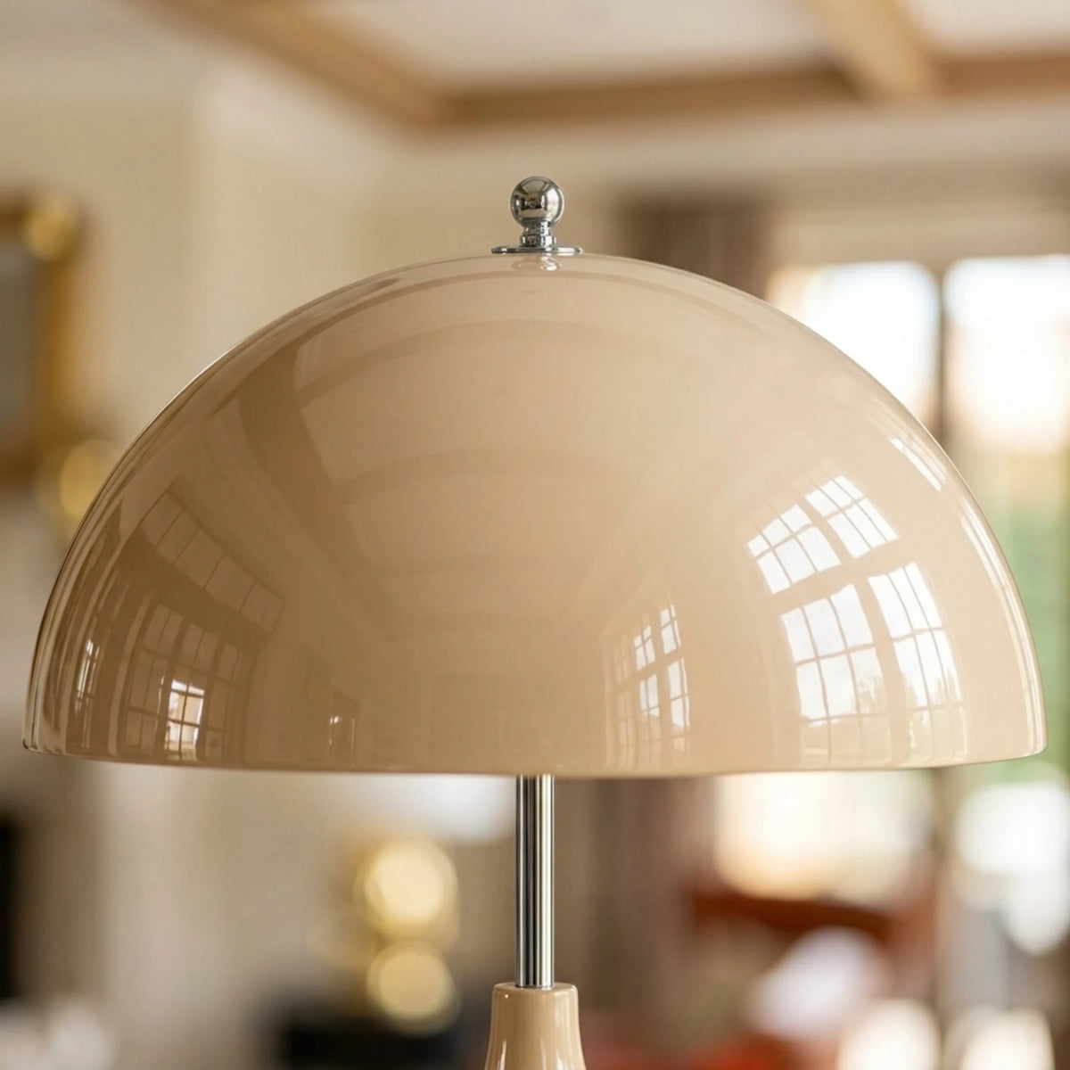 Gros plan sur l’abat-jour en dôme blanc cassé brillant du lampadaire, avec bord et bouton supérieur argentés.