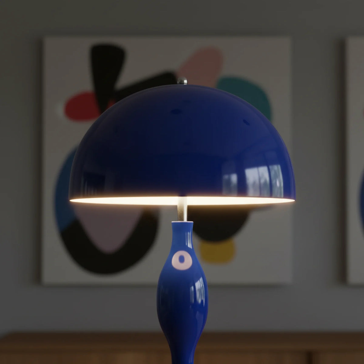 Gros plan sur l'abat-jour champignon bleu allumé, lumière douce sous le dôme