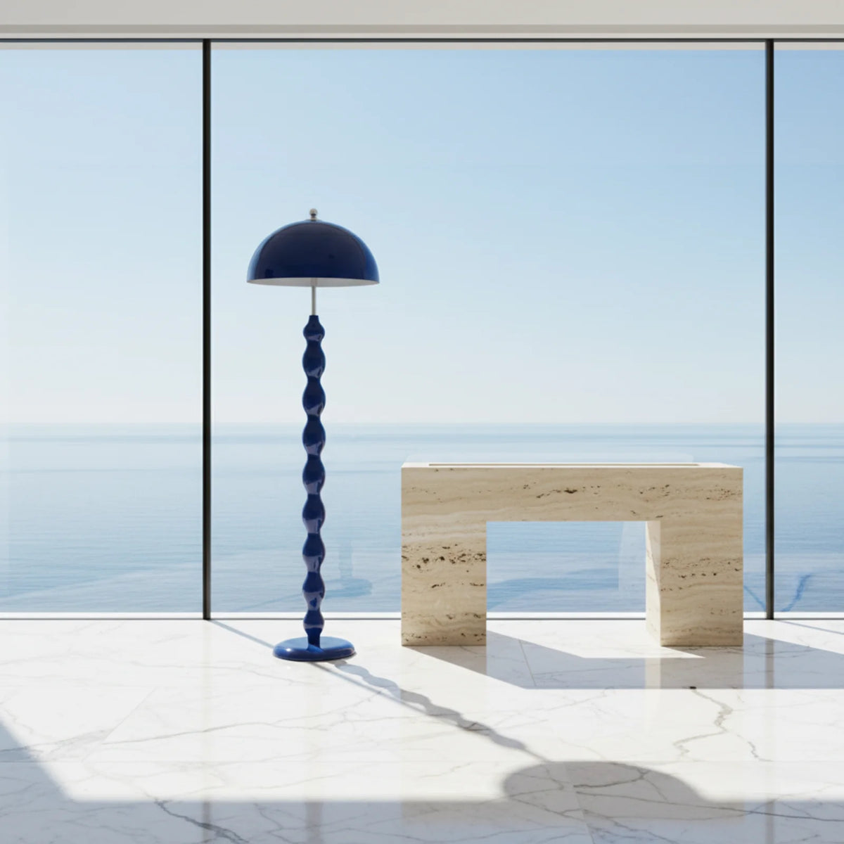 Lampadaire bleu à côté d'une console en travertin, devant une baie vitrée avec vue sur la mer