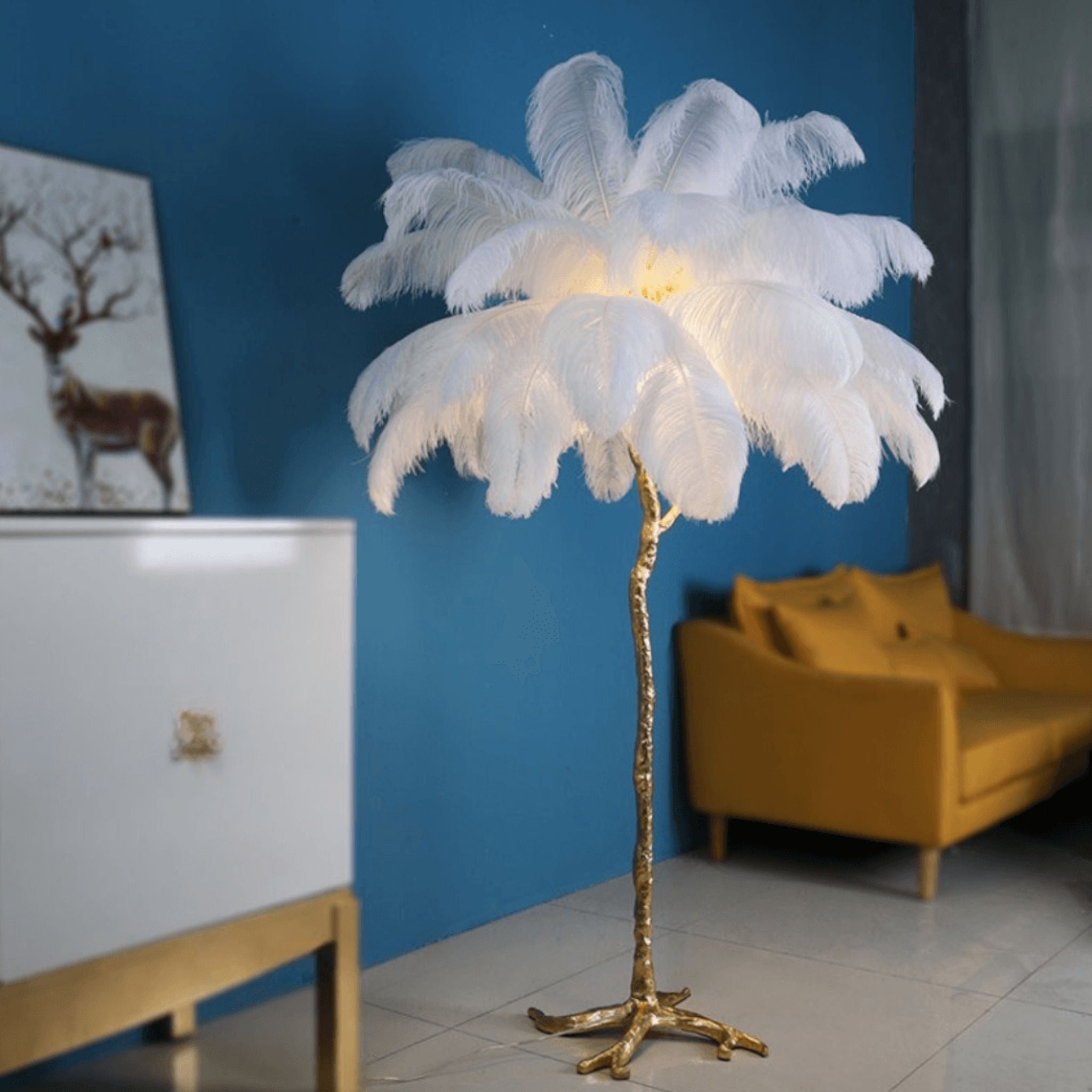 Ambiance élégante avec lampadaire palmier en plumes blanches, base dorée, éclairage LED pour salon contemporain.