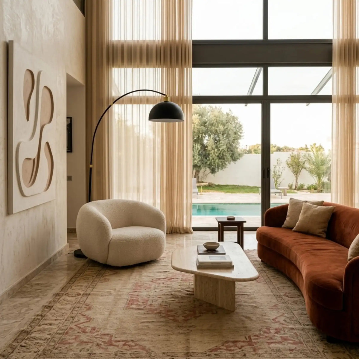 Lampadaire à dôme noir au-dessus d'un fauteuil bouclette, près d'un canapé en velours terracotta et d'un tapis ancien