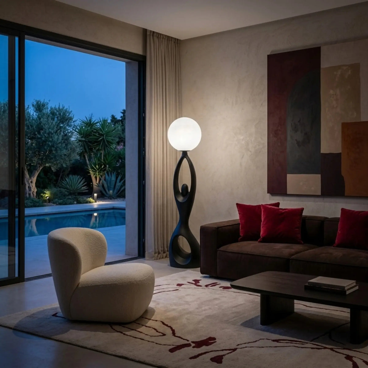 Lampadaire à globe lumineux près d'un fauteuil bouclette, salon ouvert sur le jardin le soir