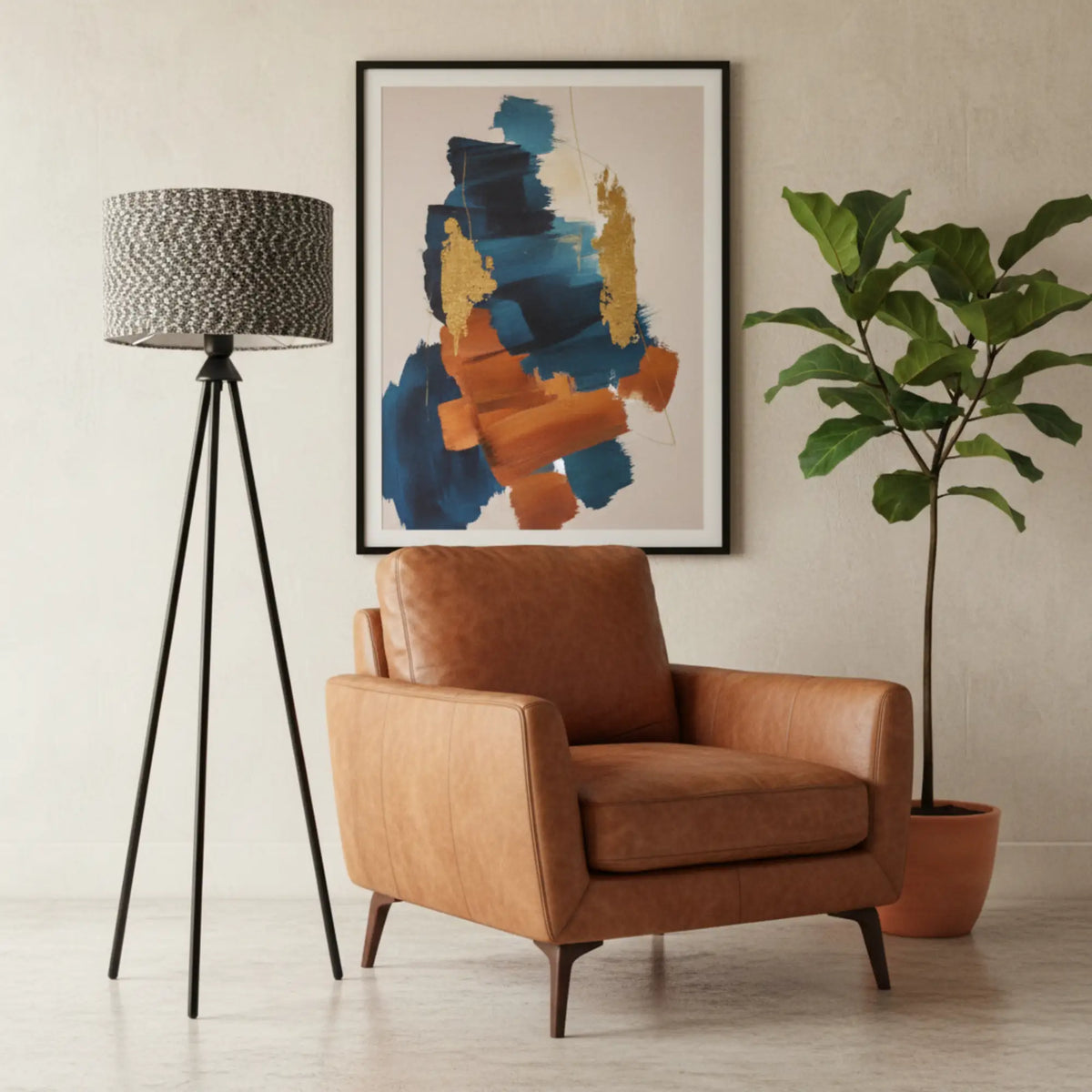 Lampadaire trépied noir à abat-jour chiné à côté d'un fauteuil en cuir cognac, sous un tableau abstrait coloré