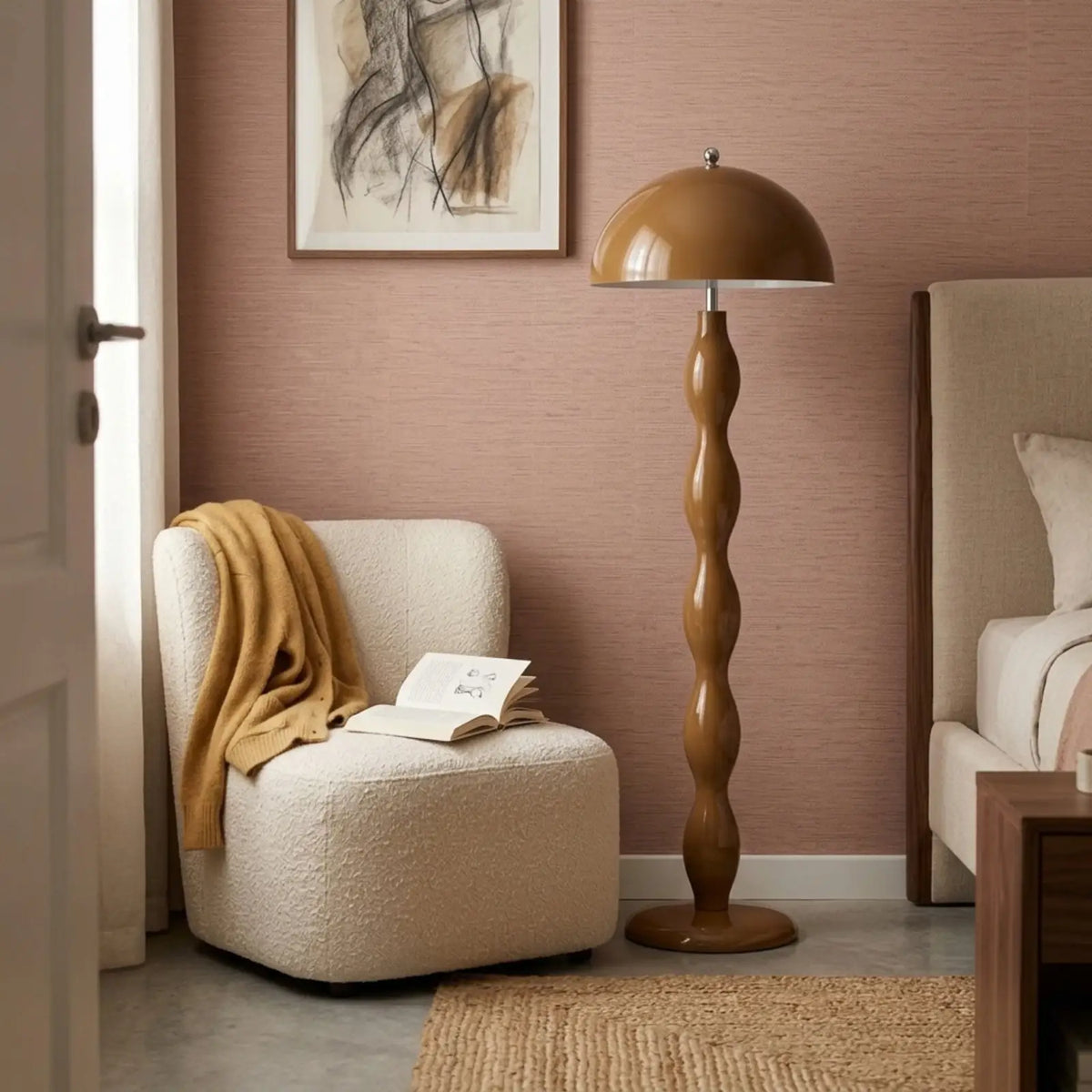 Lampadaire marron dans une chambre aux murs rose poudré, entre un fauteuil bouclé et le lit