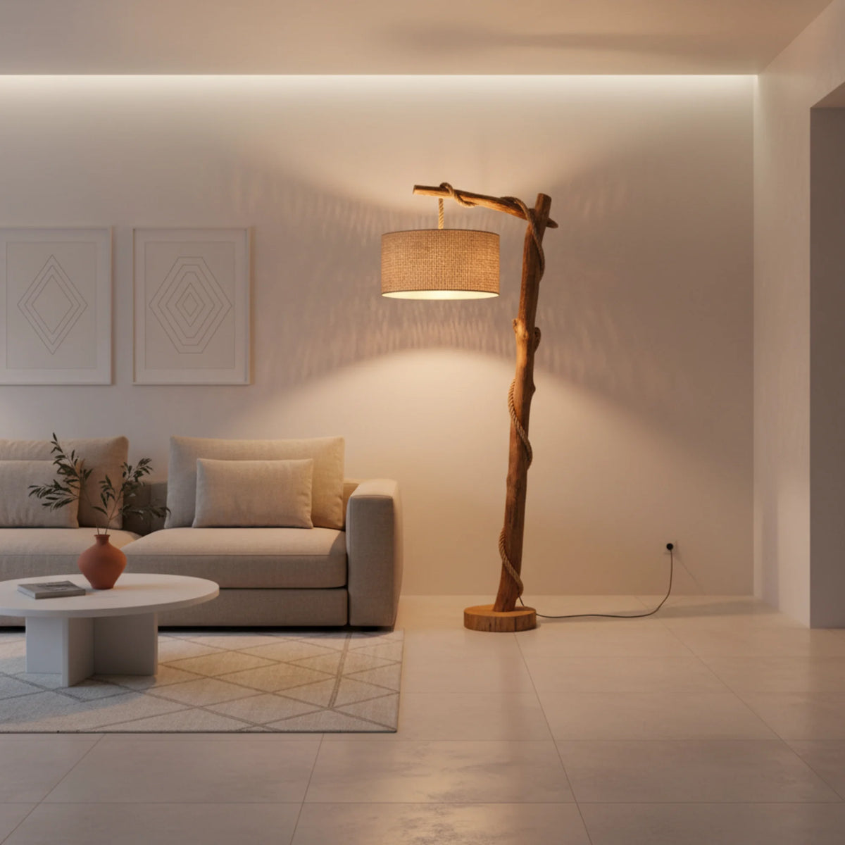 Lampadaire moderne en bois et corde de jute dans un salon épuré, à côté d'un canapé beige et d'une table basse blanche ronde