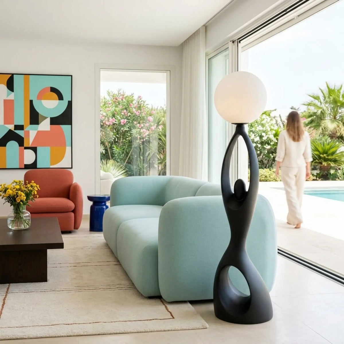 Lampadaire moderne noir dans un salon coloré avec canapé bleu ciel ouvert sur la piscine
