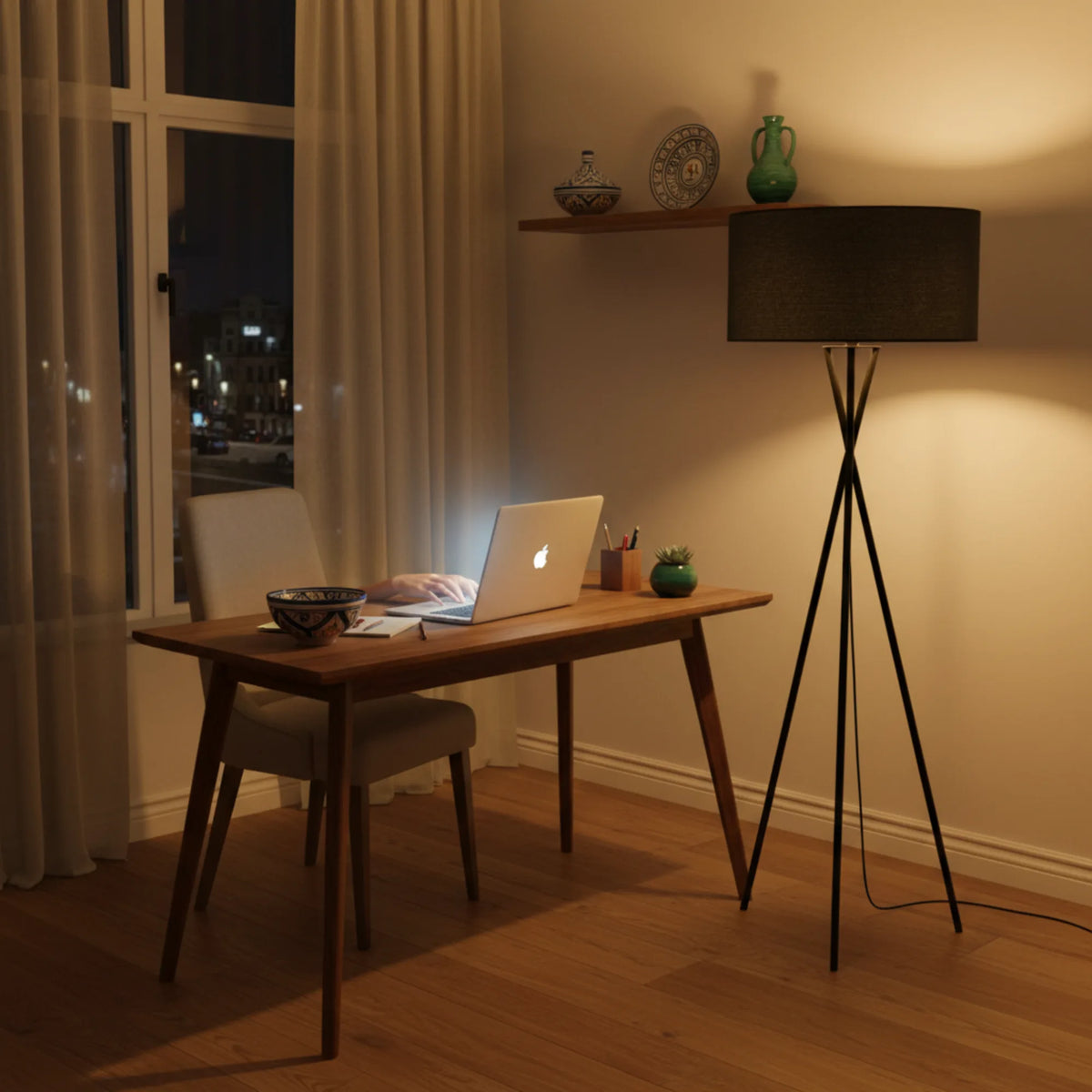 Lampadaire noir allumé le soir à côté d'un bureau en bois avec ordinateur portable