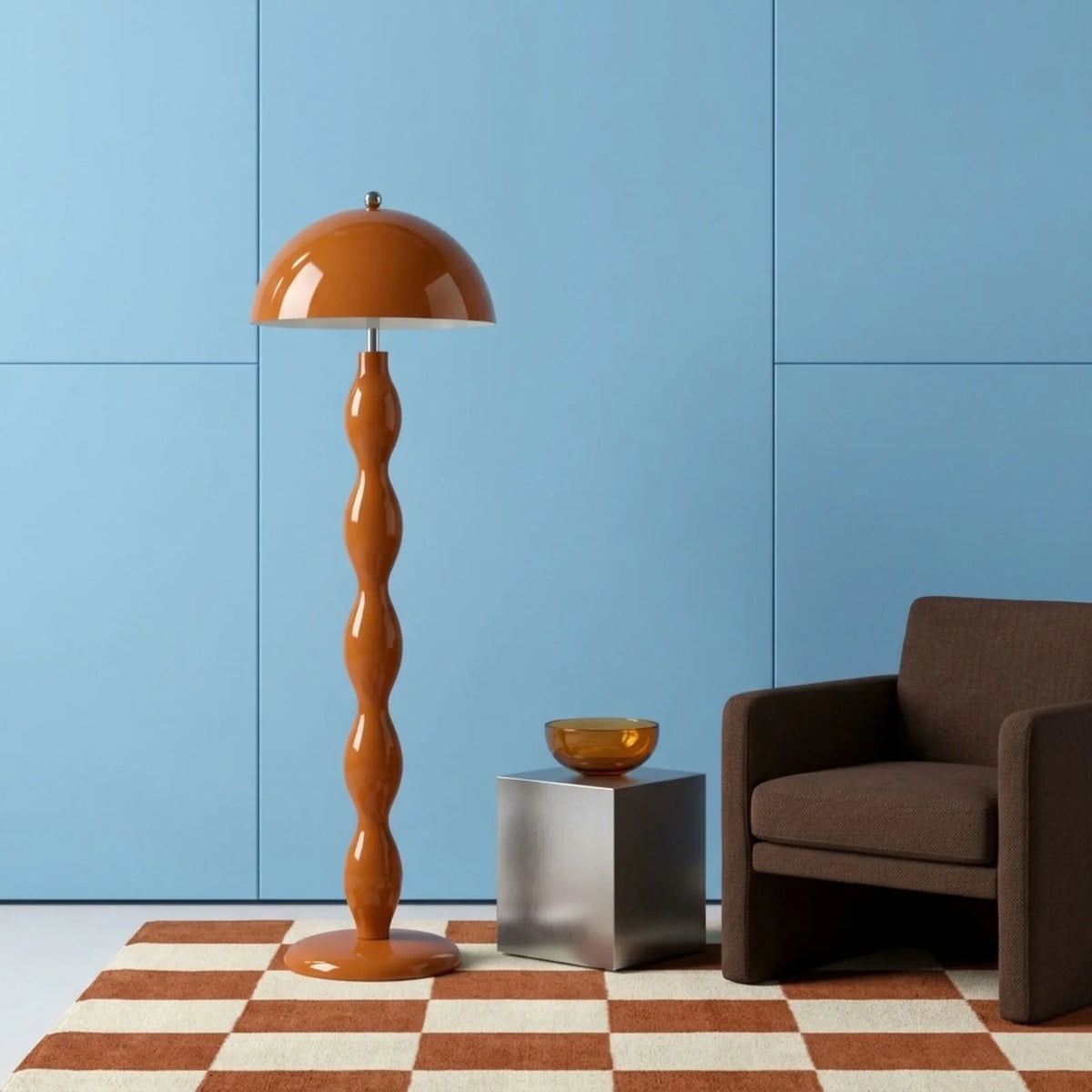 Lampadaire orange devant un mur bleu ciel, sur un tapis à damier terracotta, à côté d'un fauteuil marron