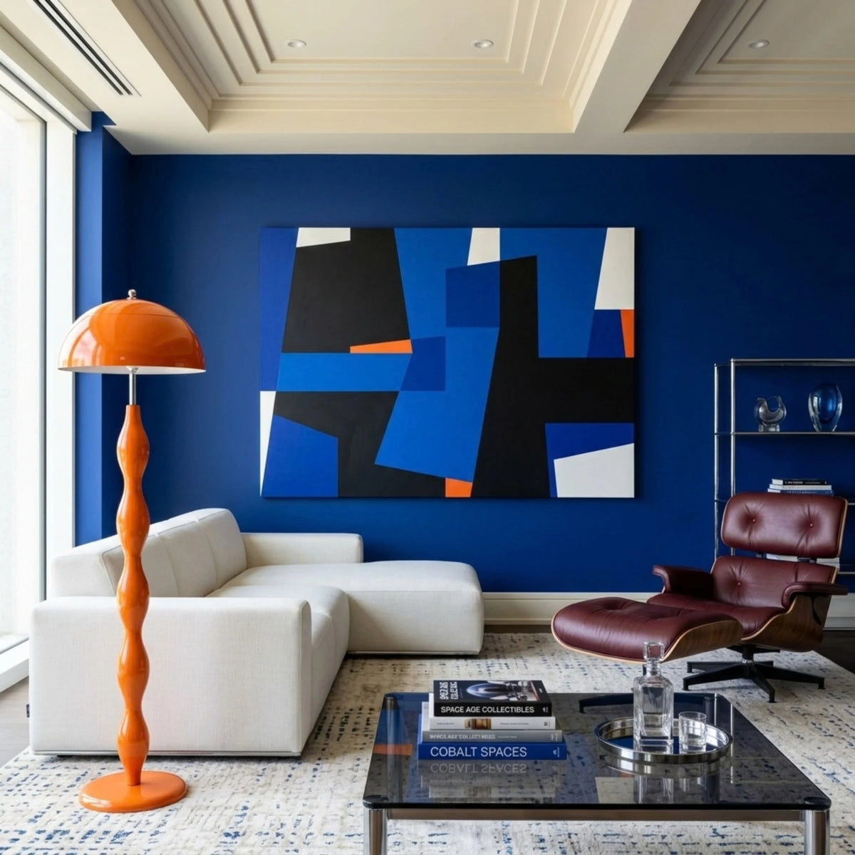 Lampadaire de salon orange devant un mur bleu nuit, canapé d'angle blanc et tableau abstrait bleu