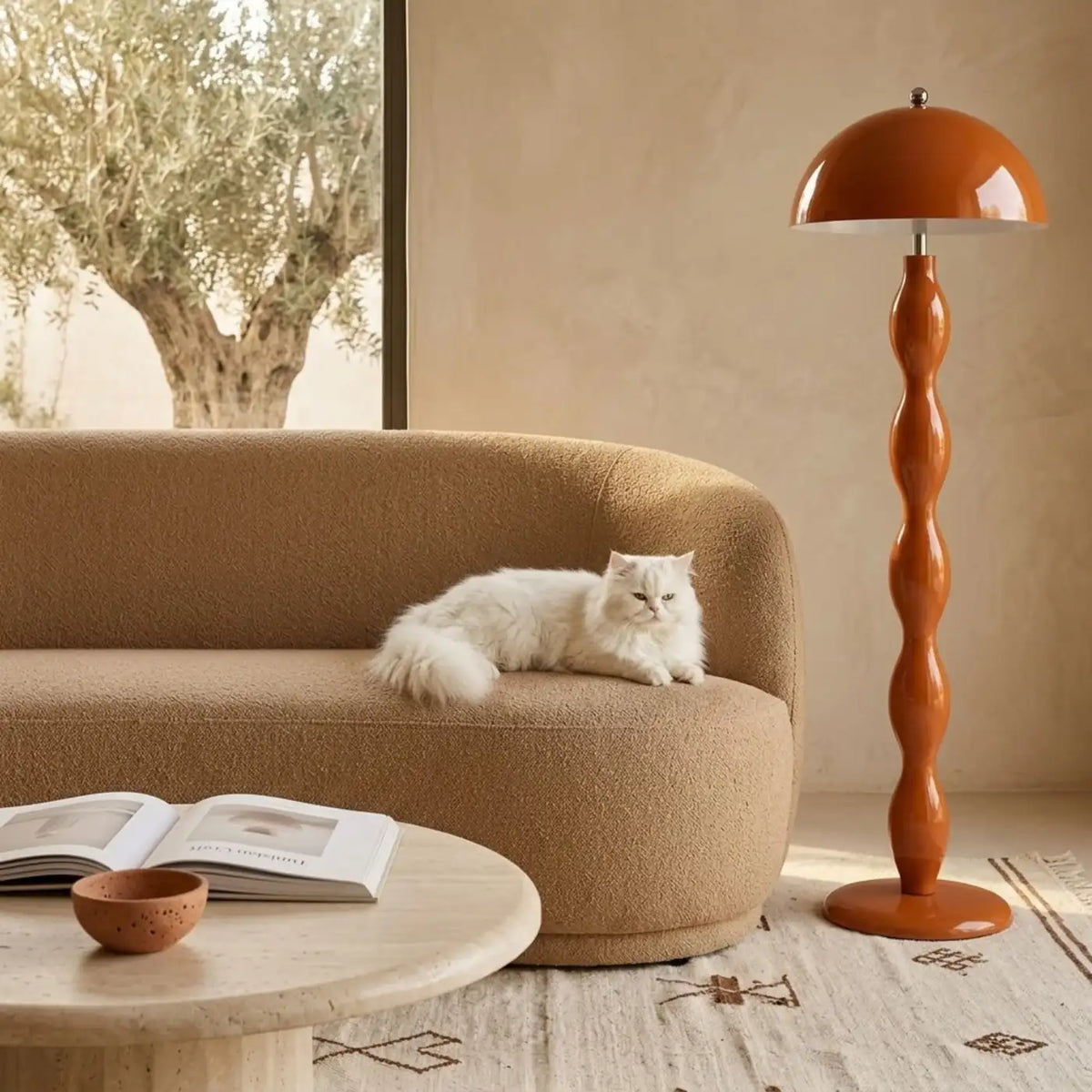 Lampadaire orange terracotta à côté d'un canapé bouclette beige sur un tapis berbère