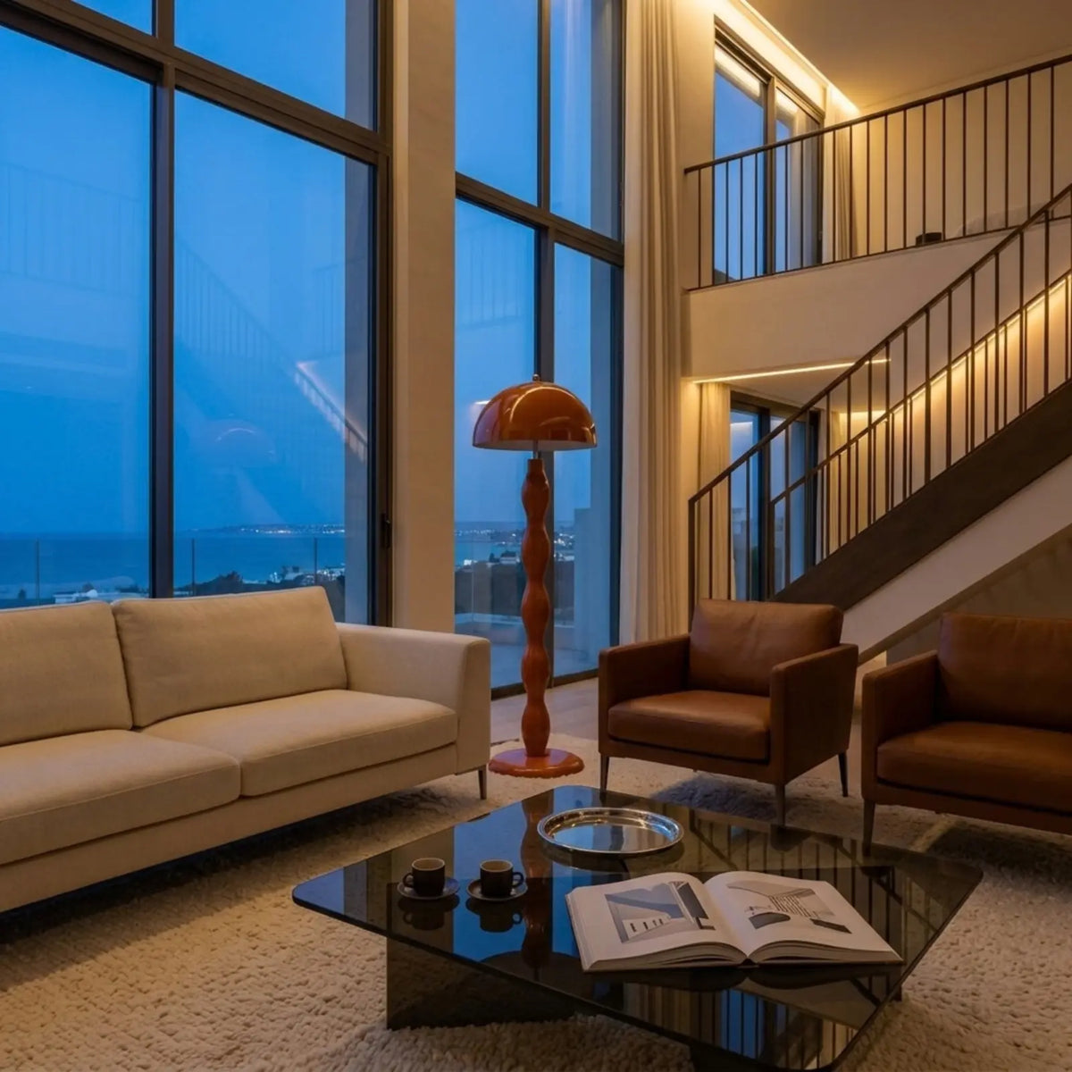 Lampadaire orange allumé dans un salon en duplex avec vue sur mer le soir