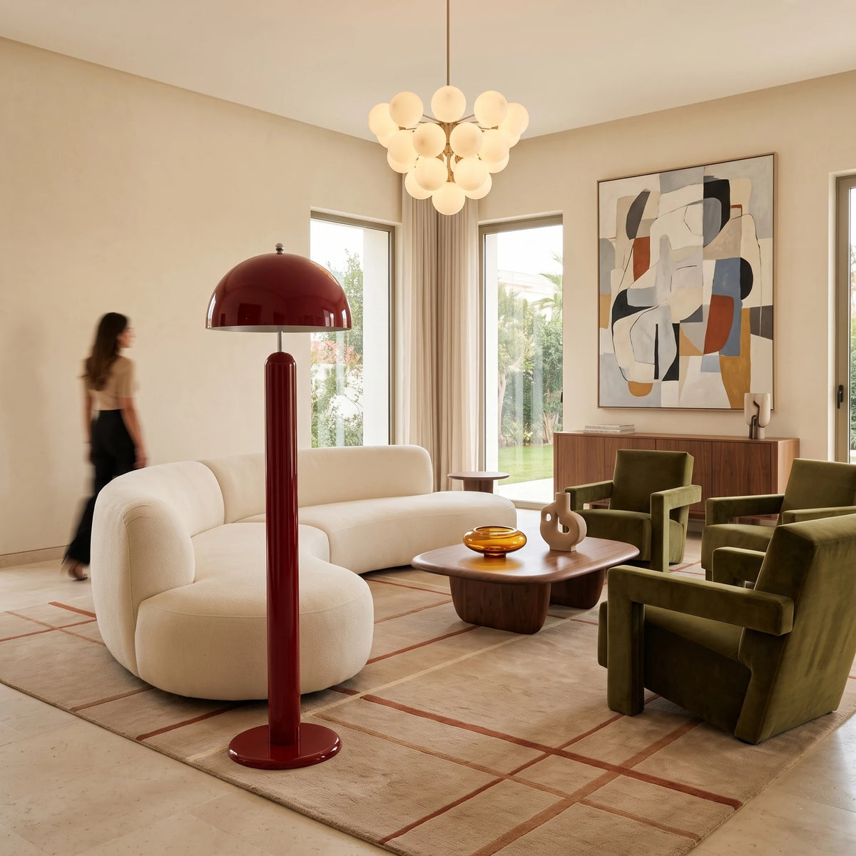 Lampadaire de salon rouge carmin près d'un canapé arrondi blanc et de fauteuils en velours vert olive