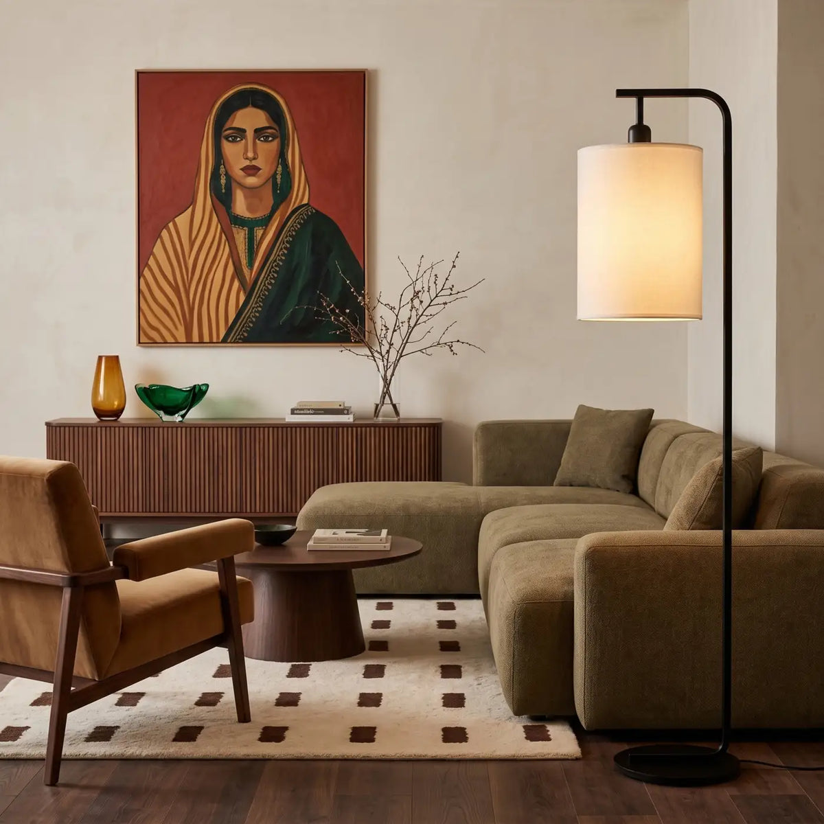 Lampadaire noir près d'un canapé d'angle vert sauge, sous un portrait peint accroché au mur