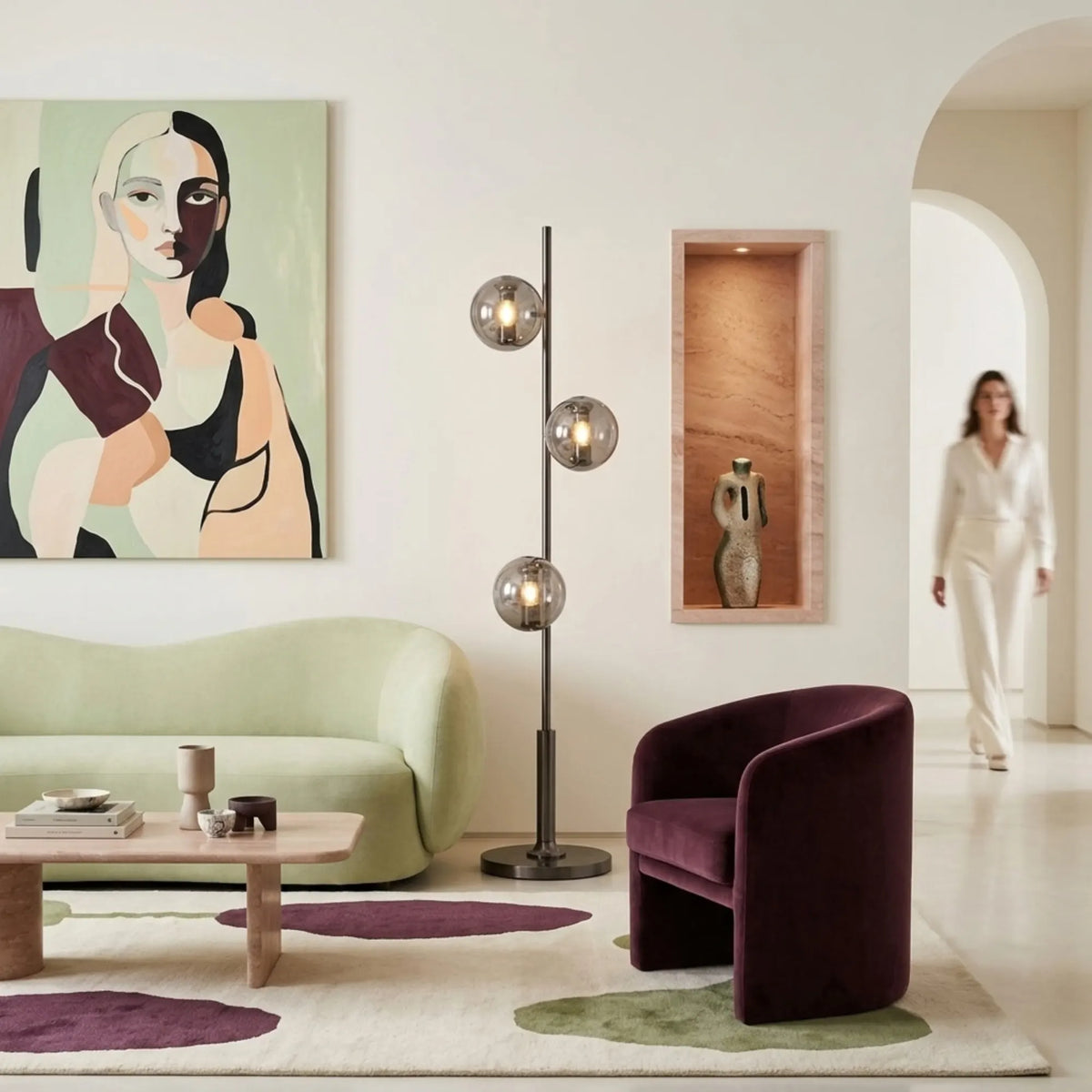 Lampadaire à globes fumés dans un salon clair entre un canapé vert et un fauteuil prune