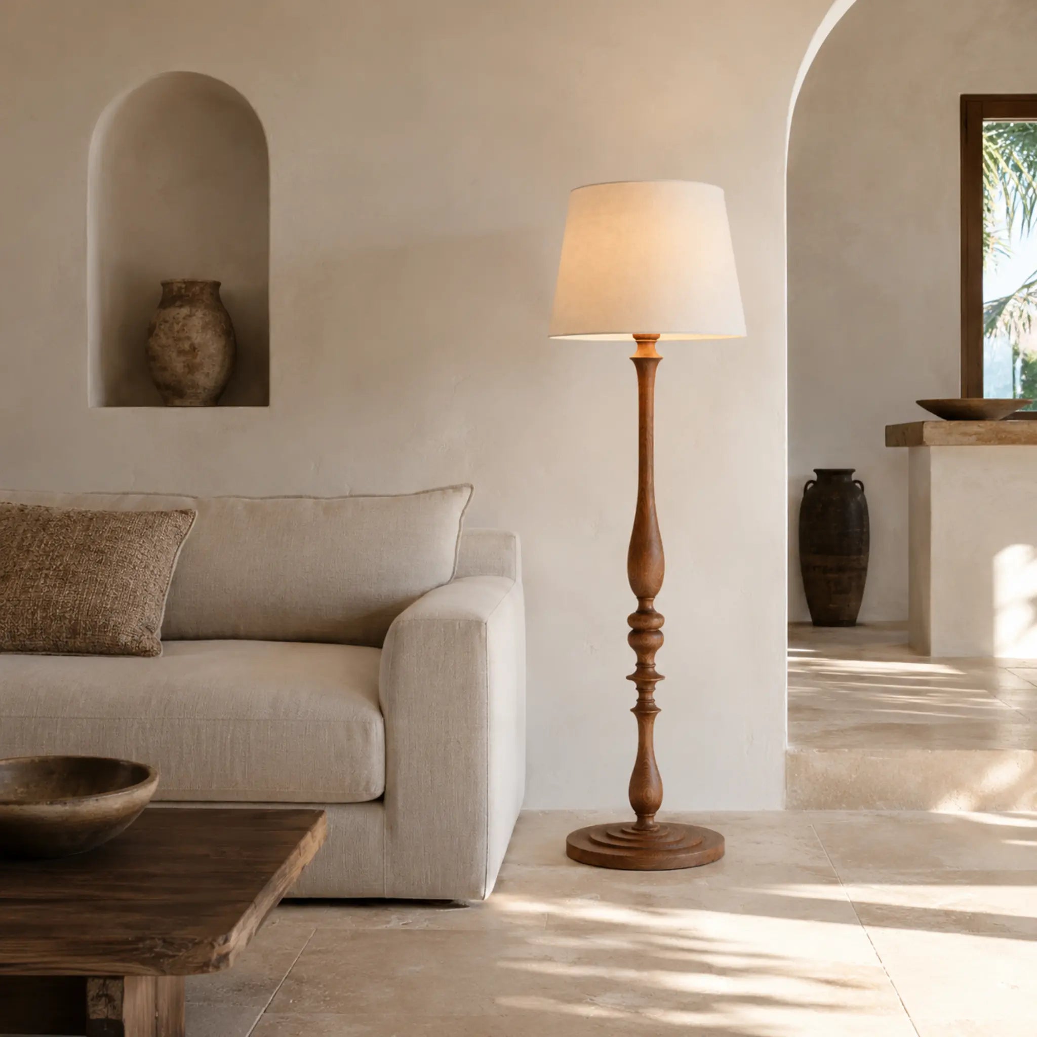 Lampadaire sur pied en bois tourné dans un salon méditerranéen aux murs blancs avec arches, décoration Tunisie